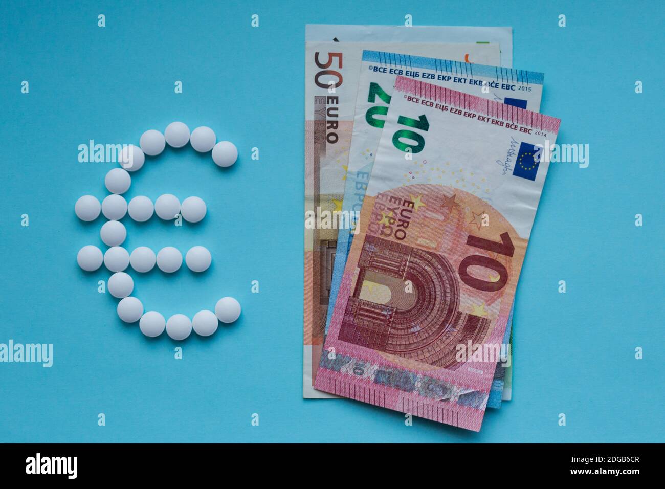 Pillen und Euro auf blauem Hintergrund. Teure Medizin Konzept Stockfoto