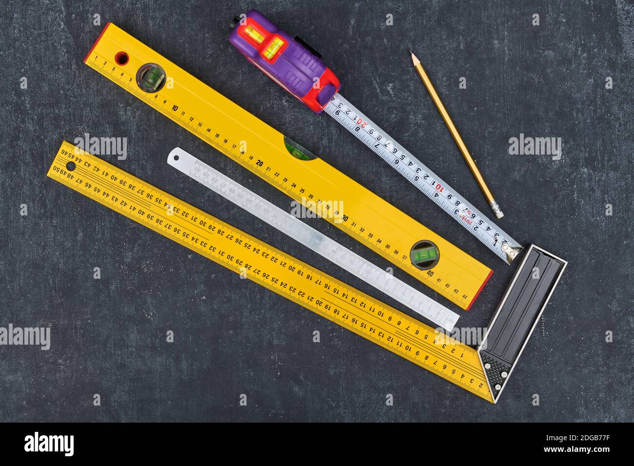 Lineal, Maßband, Konstruktionsebene und Bleistift auf grauem Hintergrund, Nahaufnahme von oben Stockfoto