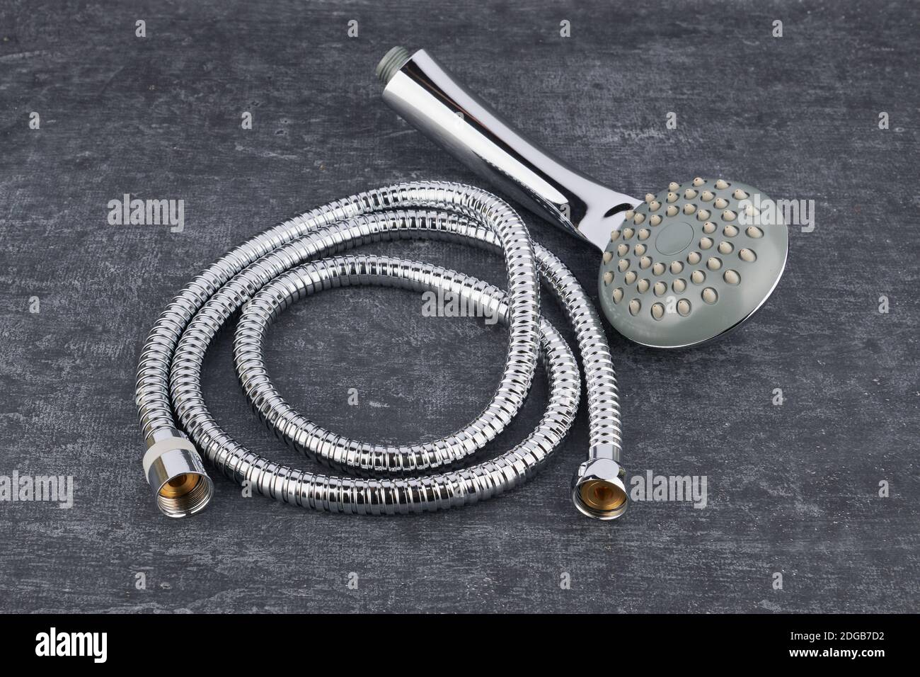 Duschkopf und flexibler Verbindungsschlauch Nahaufnahme auf grauem schäbigen Hintergrund Stockfoto