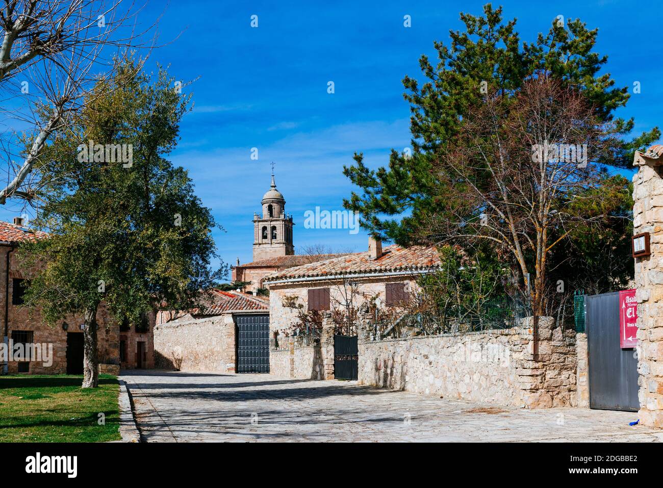 Dorfstraße, Hervorhebung der Glockenturm der Stiftskirche unserer Lieben Frau von der Himmelfahrt - Colegiata de Nuestra Señora de la Asunción. Medinin Stockfoto