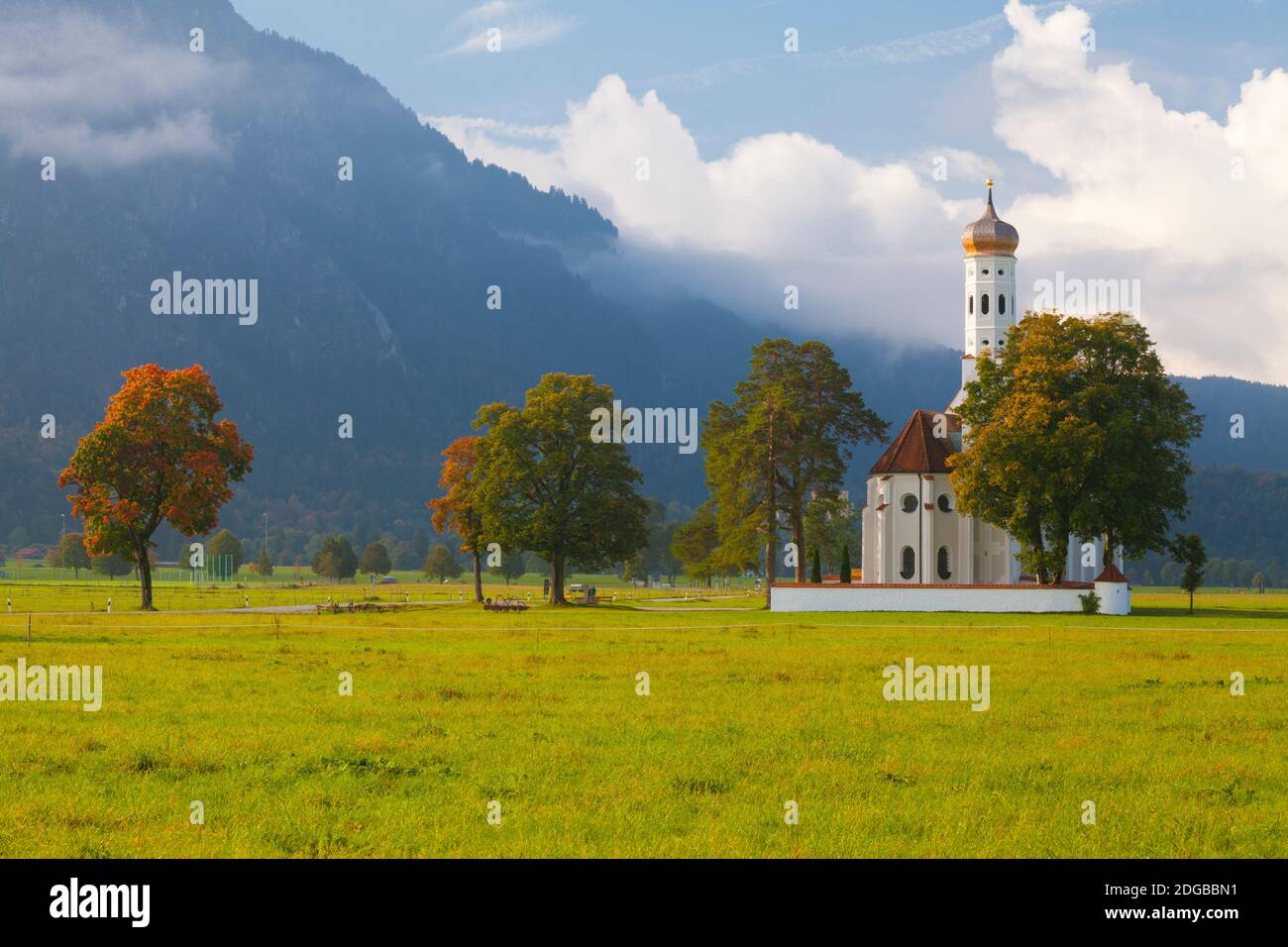 Kirche mit einem Schloss im Hintergrund, St. Coloman Kirche, Schloss Neuschwanstein, Füssen, Allgau, Bayern, Deutschland Stockfoto