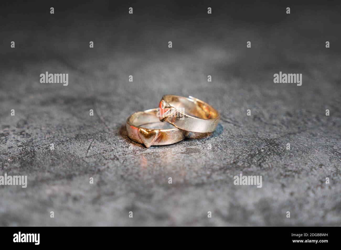 Alte Ringe mit Herz auf steinigem Hintergrund Stockfoto