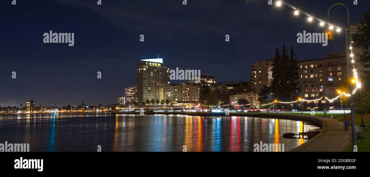 Gebäude am Wasser bei Nacht, Lake Merritt, Oakland, Kalifornien, USA Stockfoto