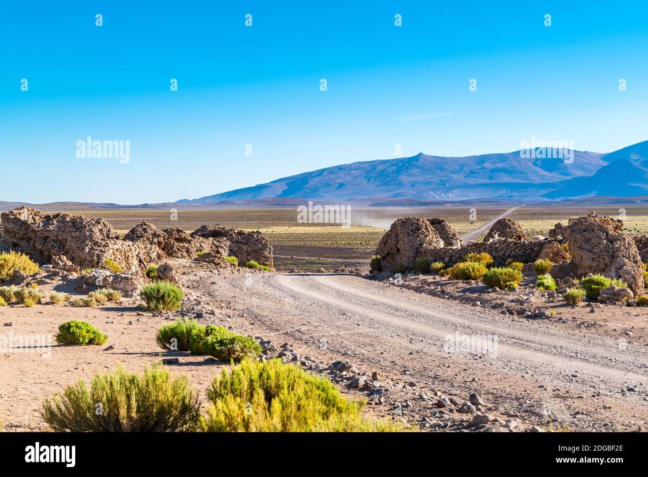 Blick auf eine Straße, die durch landwirtschaftliche Feld zu einem Berg Stockfoto