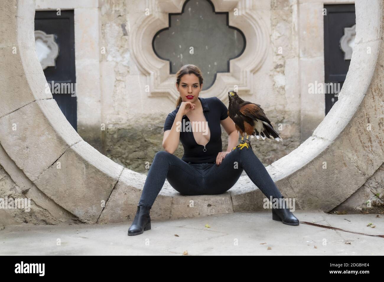 Eine schöne hispanische Brünette Modell posiert im Freien mit EINEM Falcon In EINER Hacienda Stockfoto