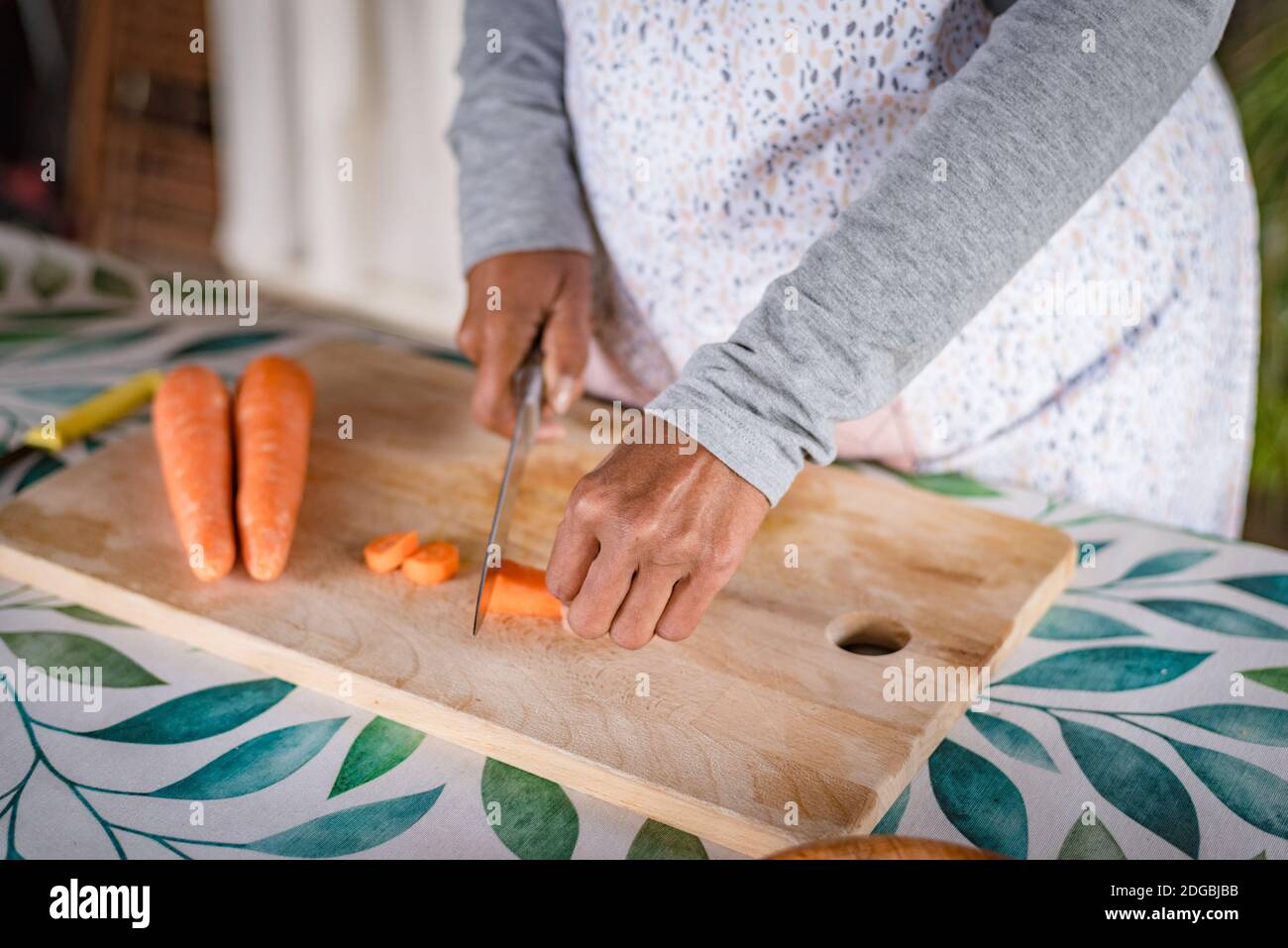 Schwarze Frau mit Brille lehrt online mit ihrem Handy Kochkurse von zu Hause Stockfoto