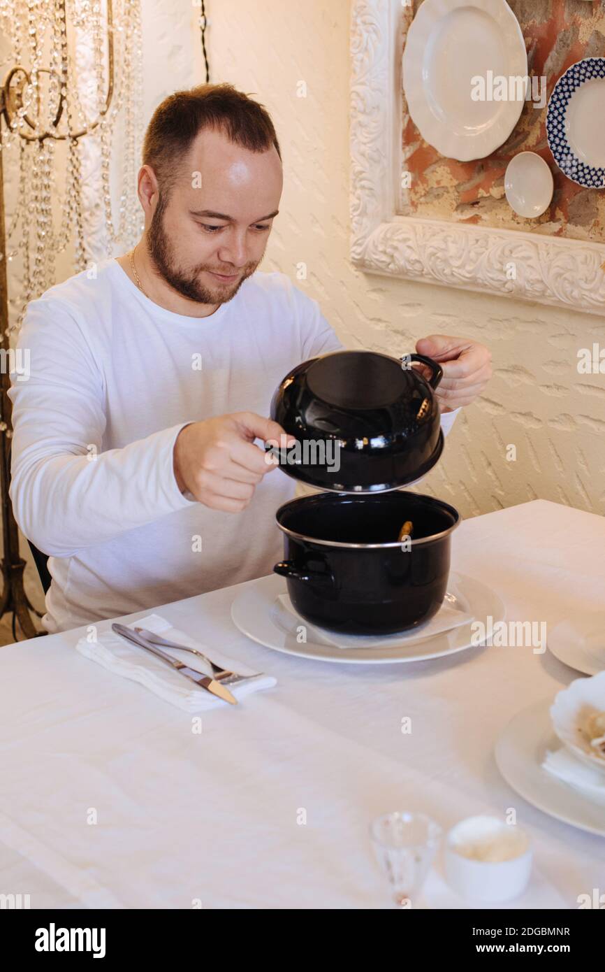 Mann, der in einem Restaurant gedünstete Muscheln isst Stockfoto