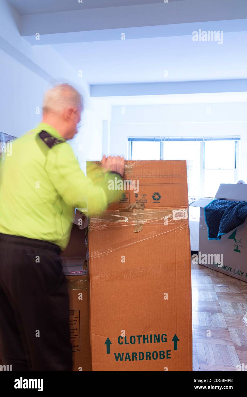 Senior Mann Auspacken in seiner neuen Wohnung in New York City, USA Stockfoto