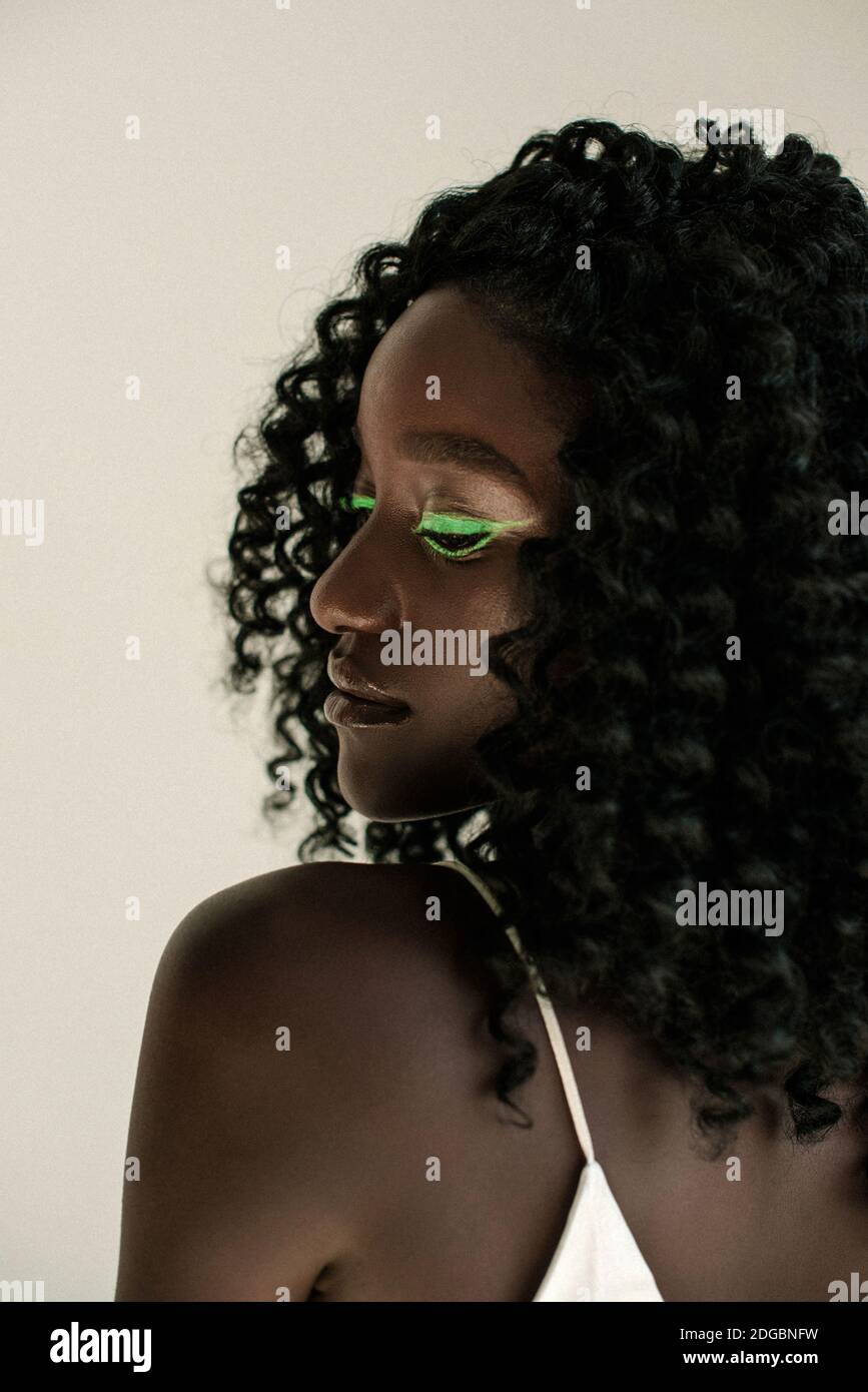 Porträt eines schönen afrikanischen Mädchen mit grünen Make-up Über ihre Schulter schauen Stockfoto