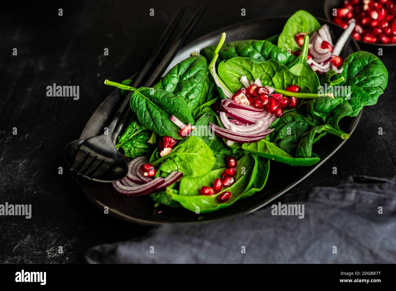 Bio-Spinatsalat mit roten Zwiebeln und Granatapfel Stockfoto
