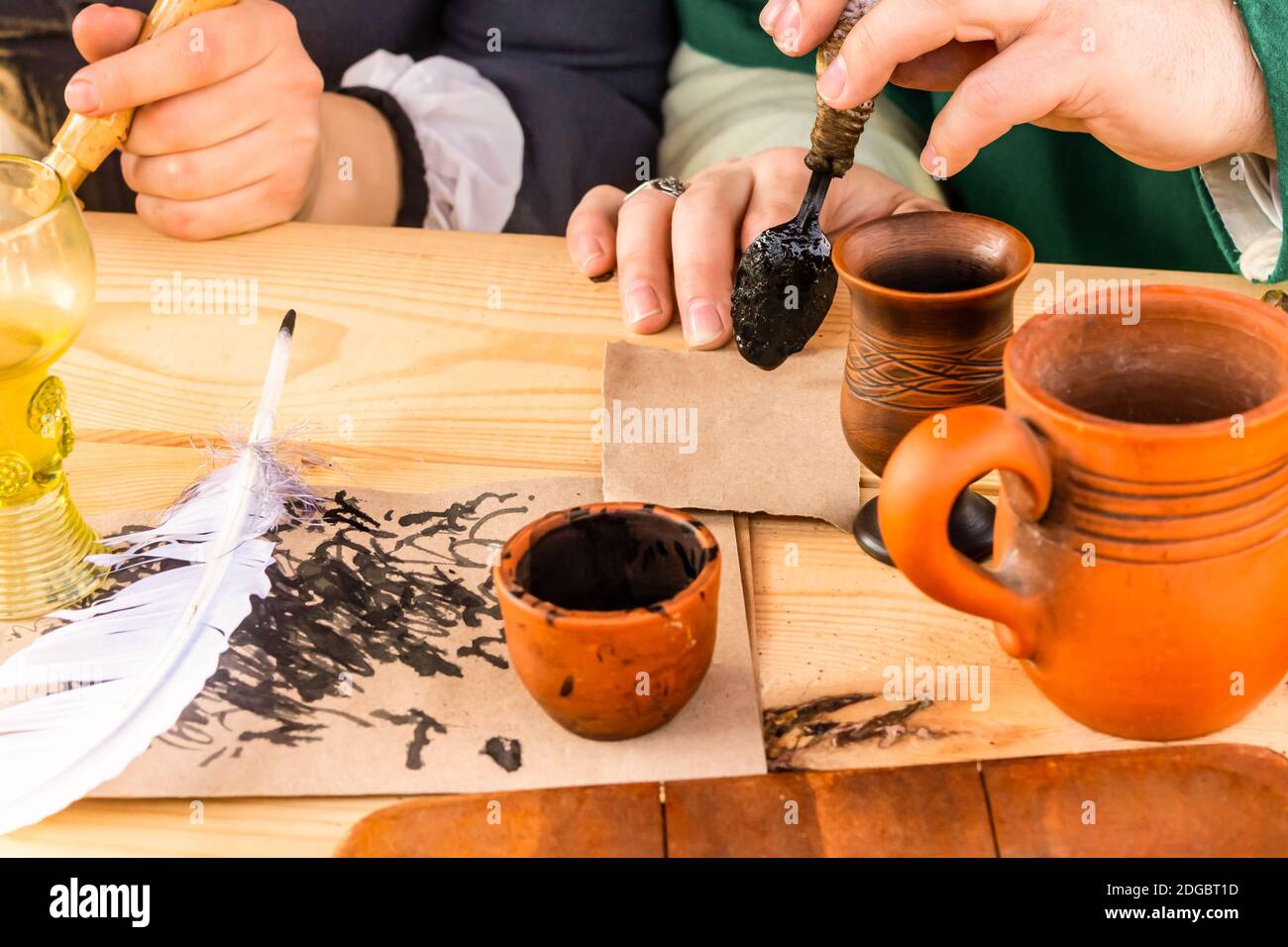 Eine Tintenfass mit einem weißen Federkiel traditionellen handgeschriebenen Zubehör Stell dich auf einen Holztisch Stockfoto