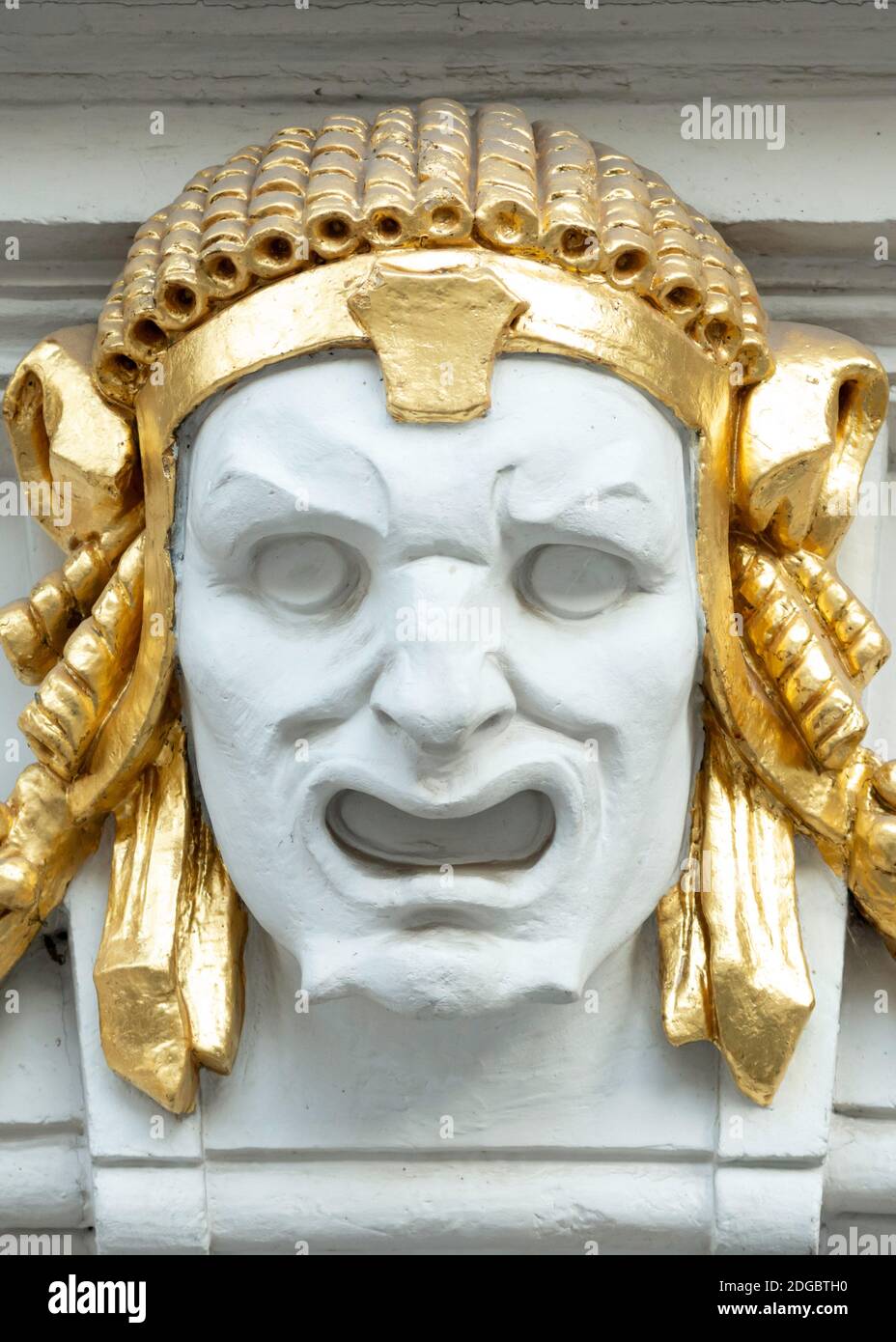 Ornamental Detail und architektonisches Element der theatralischen Maske Darstellung des Menschen Gesicht mit goldenen Details an der Fassade des Theatergebäudes in Sofia Bulgarien Stockfoto