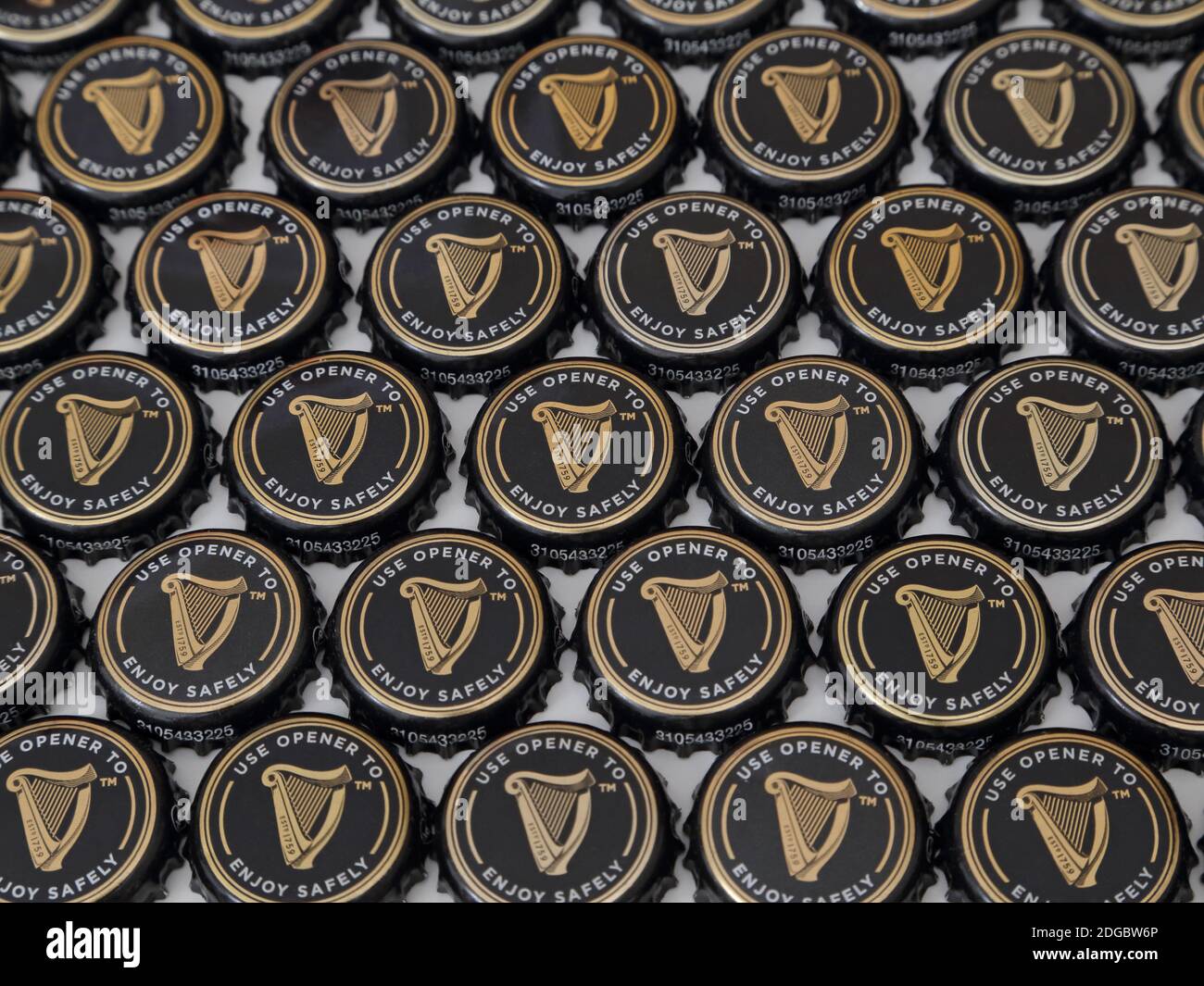 Eine Sammlung von Guinness Bierflaschen-Verschlüssen sind in einem flachen Display angeordnet, in einem Winkel in den 2020er Jahren betrachtet. Nur für redaktionelle Zwecke. Stockfoto