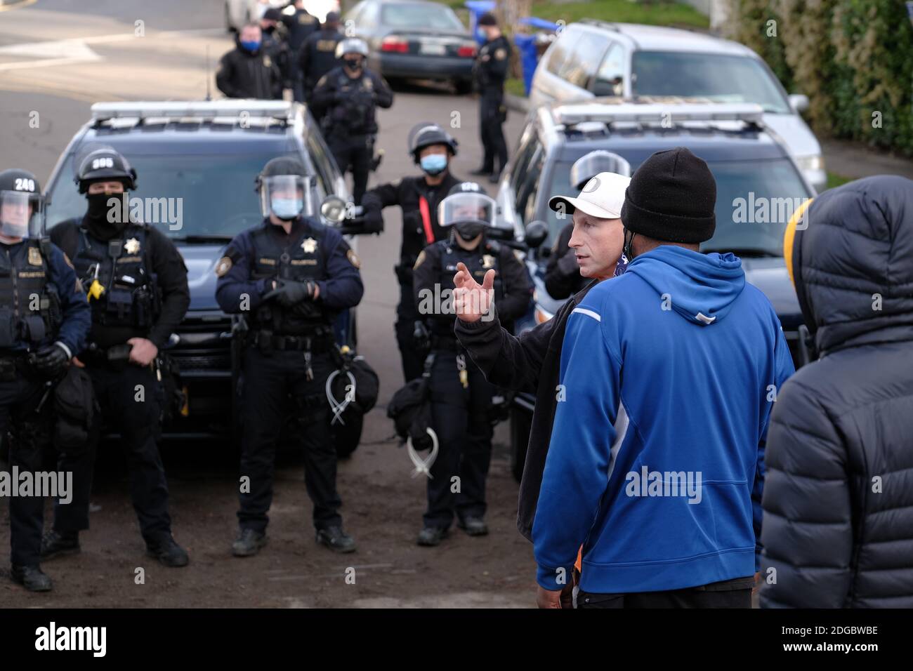 Portland, USA. Dezember 2020. Polizeibeamte treten am 8. Dezember 2020 mit Demonstranten hinter dem Roten Haus in der Mississippi Straße in Portland, Oregon, auf, als sie versuchen, das Grundstück zu vertreiben. Aktivisten zelteten seit September vor dem Haus in der Hoffnung, die dort lebende Familie der Schwarzen und Indigenen zu erhalten, nachdem ein Richter des Landkreises Multnomah die Räumung genehmigt hatte. (Foto: Alex Milan Tracy/Sipa USA) Quelle: SIPA USA/Alamy Live News Stockfoto