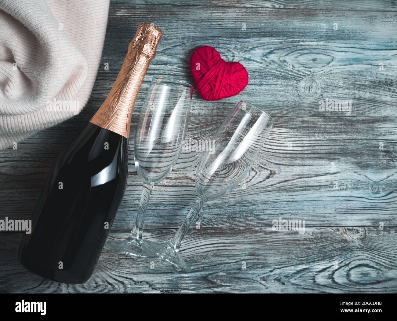 Herz, Champagner und zwei Gläser auf Holzgrund. Stockfoto