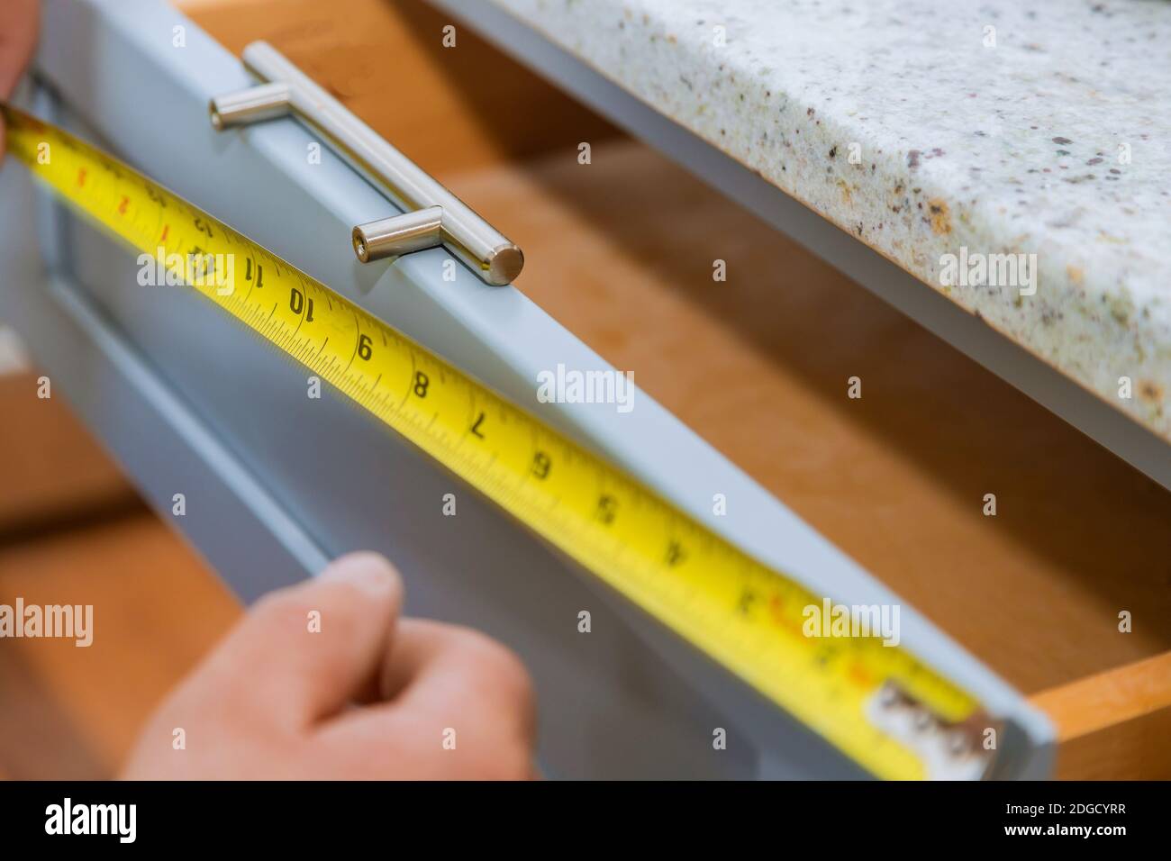 Installation von Schubladen Griffe auf Küchenschränke Stockfoto