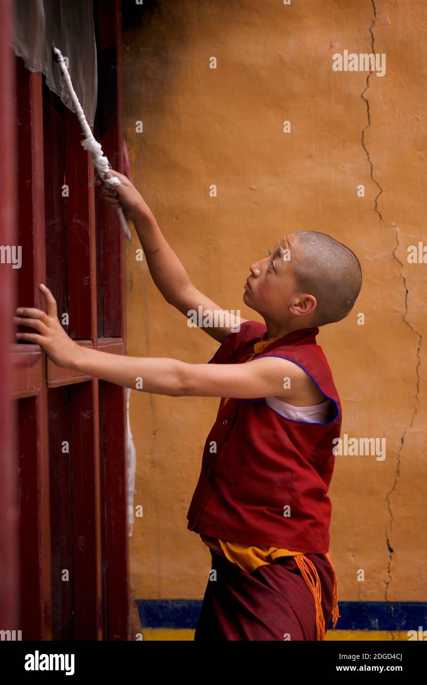 Ein junger, Novize Mönch Unternehmen Aufgaben. Lamayuru Kloster, Lamayouro, Ladakh, Jammu und Kaschmir, Indien Stockfoto