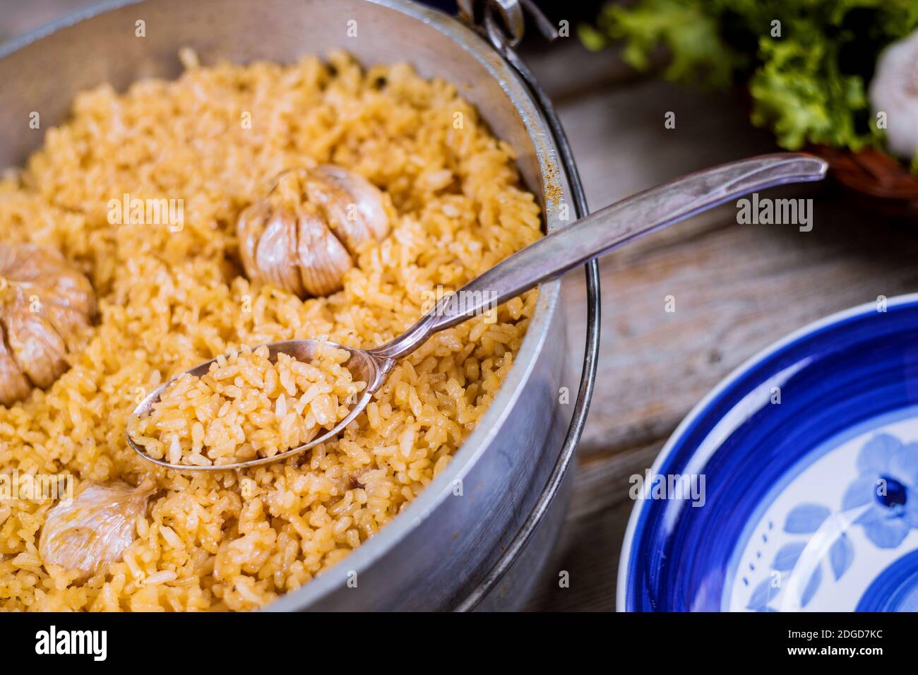Usbekischer Pilaf, Reis mit Knoblauch in Eisentopf und Teller. Stockfoto