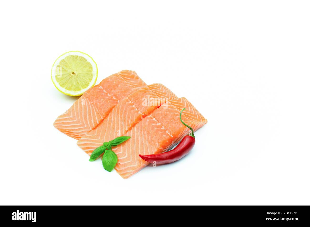 Stücke von frischem Lachs, rote Chilischote, Zitrone isoliert auf weiß Stockfoto