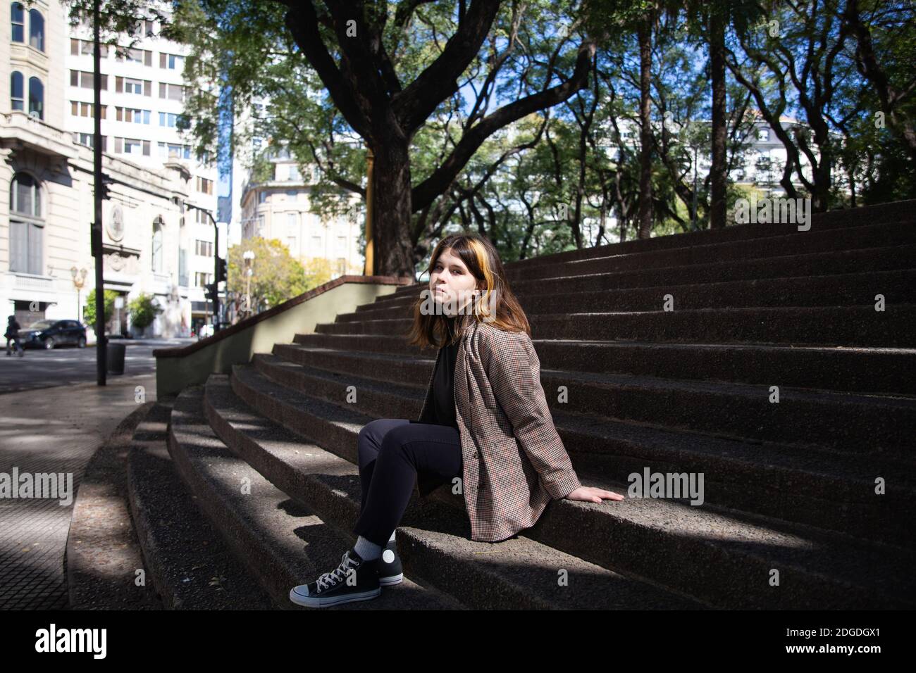 Mädchen sitzt auf den Stufen des Stadtplatzes in Buenos Aires Stockfoto