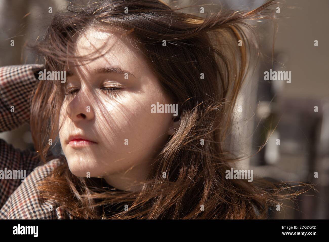 Gesicht junges Mädchen mit geschlossenen Augen und fließenden Haaren auf Ein sonniger Tag Stockfoto