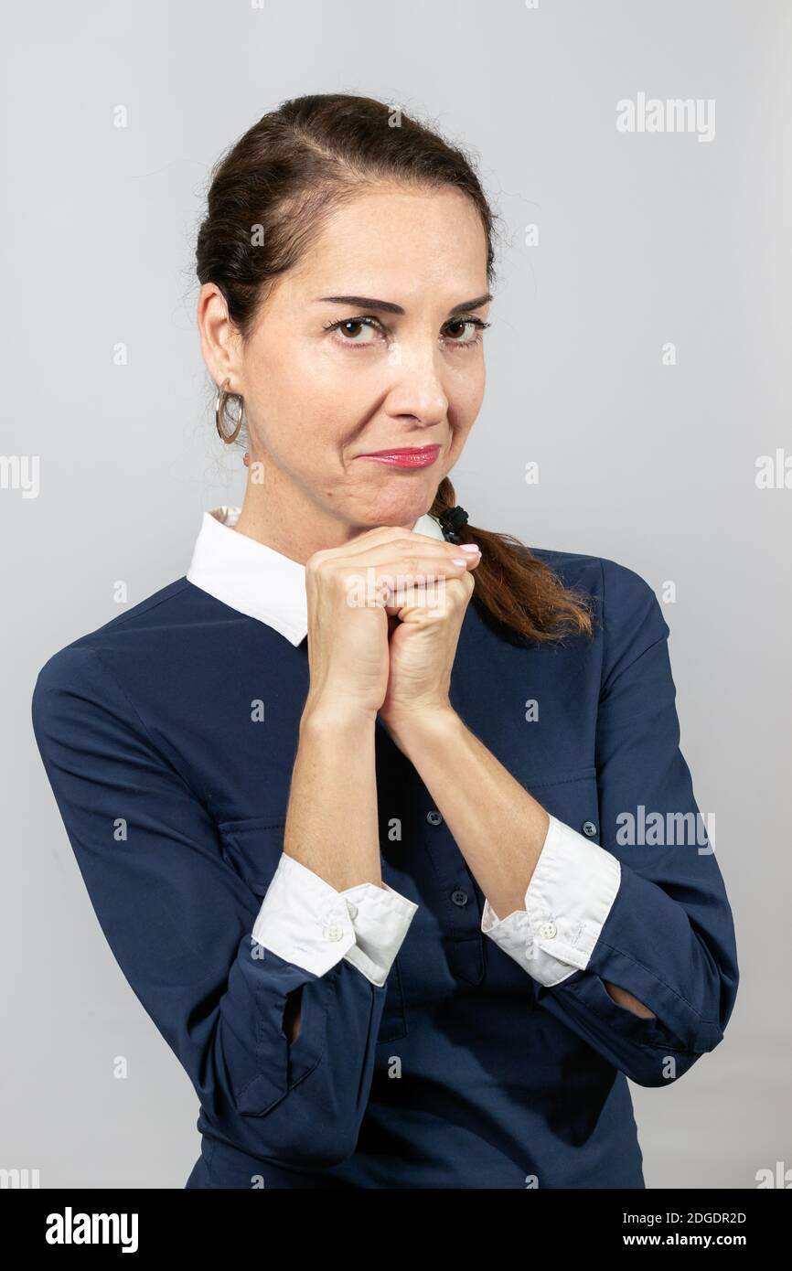 Eine Frau trägt legeres blaues Hemd mit Händen zusammen, die um Vergebung bitten, schuldiges Gesicht Stockfoto