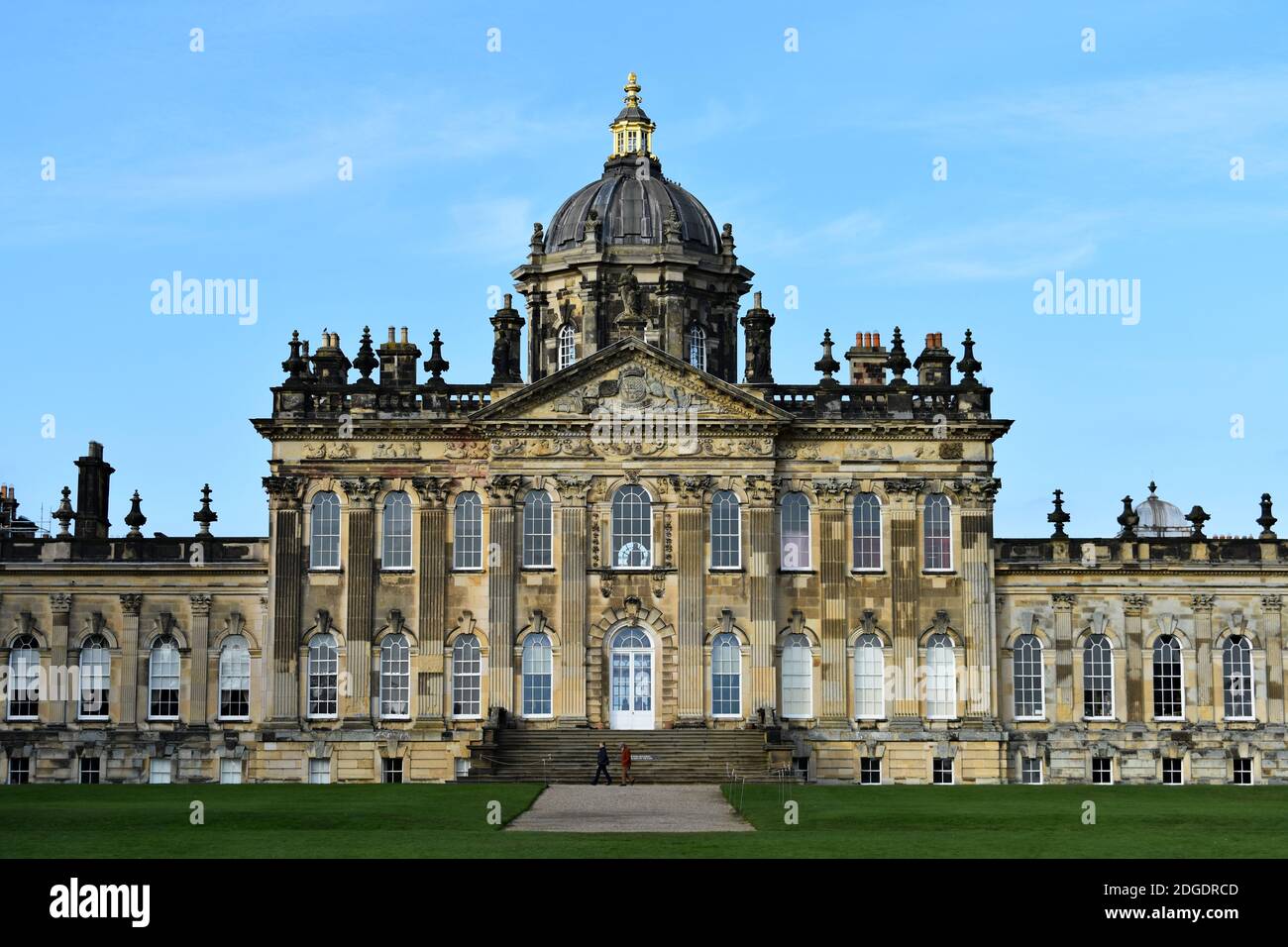 The South Front of Castle Howard, ein historisches Herrenhaus in North Yorkshire, England. Zwei Besucher gehen an einer Treppe vorbei, die zu einem hinteren Eingang führt. Stockfoto