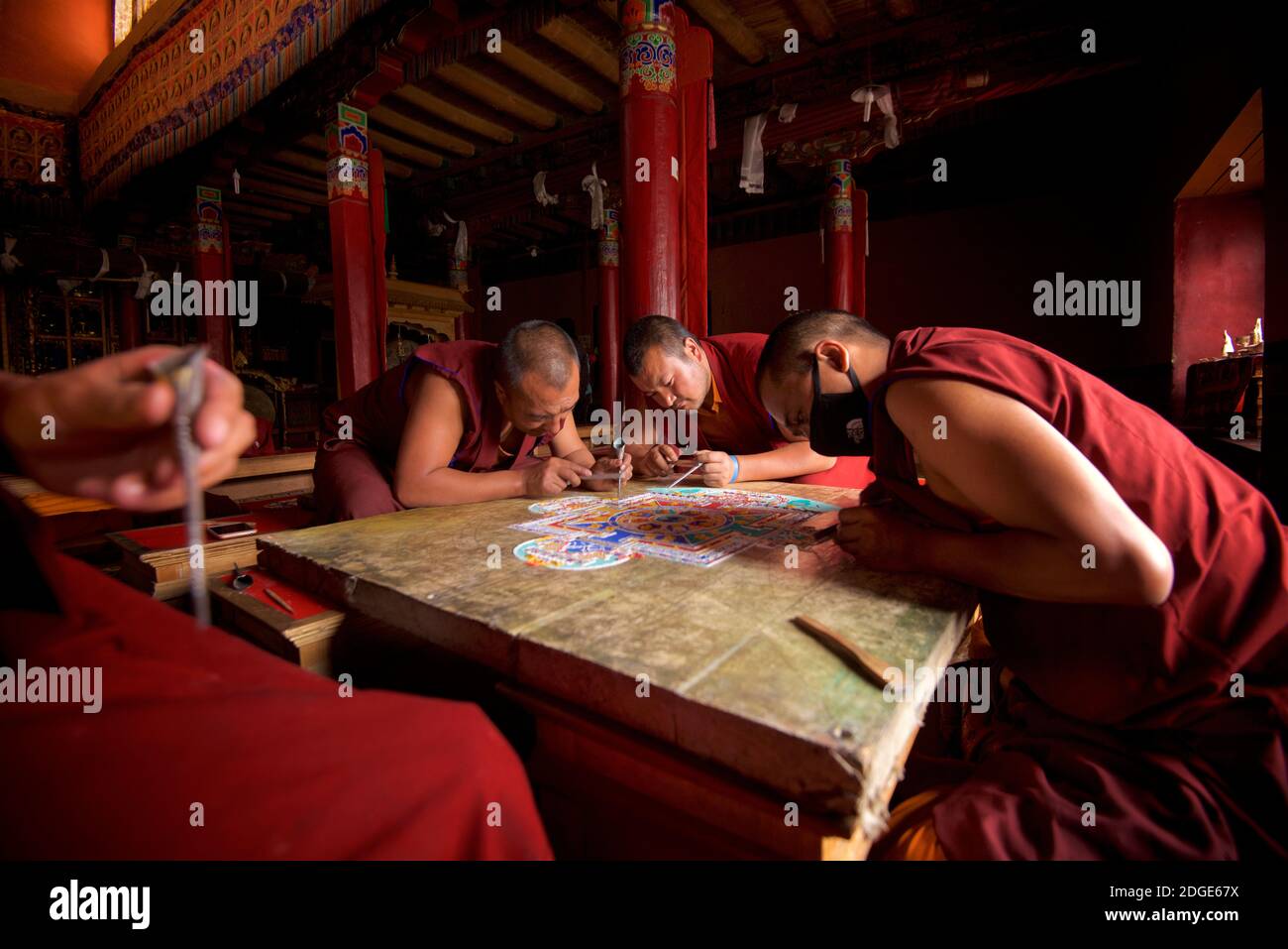 Mönche im Lamayuru Kloster, Ladakh Schaffung eines Mandala von farbigem Sand. Lamayouro, Ladakh, Jammu und Kaschmir, Indien. Ein Sandmandala wird ritualistisch abgebaut, sobald es abgeschlossen ist und seine begleitenden Zeremonien und das Betrachten beendet sind, um den buddhistischen doktrinären Glauben an die vorübergehende Natur des materiellen Lebens zu symbolisieren. Stockfoto