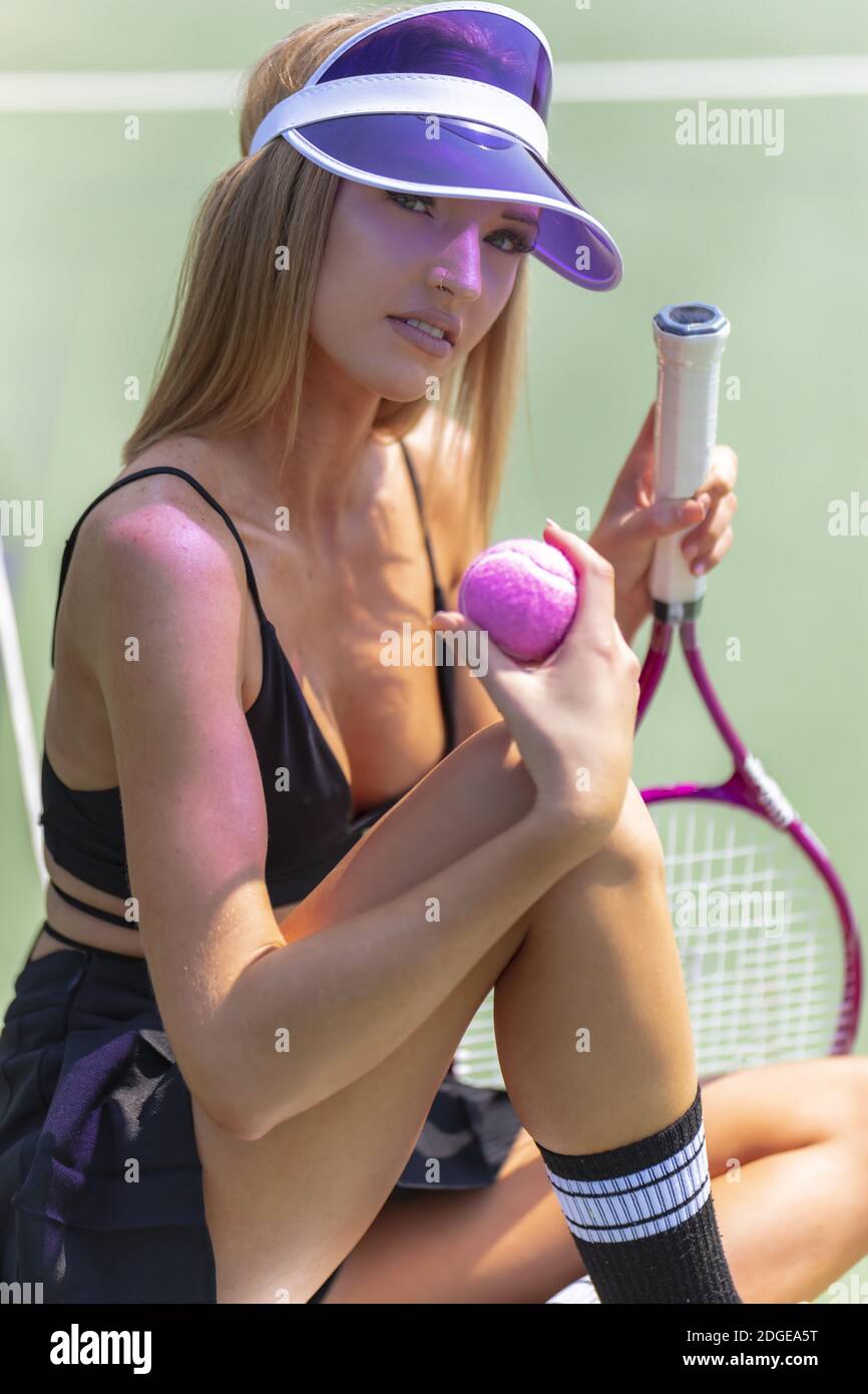 Ein schönes blondes Modell spielt Tennis auf EINEM heißen Sommer Tag Stockfoto