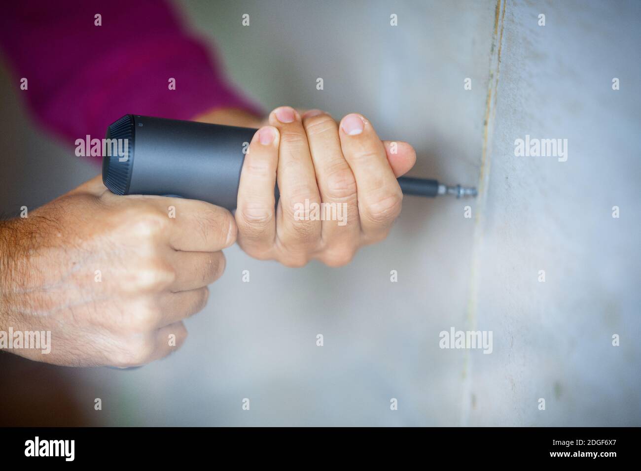 Arbeiten zu Hause mit Bohrer und Schraubendreher Stockfoto