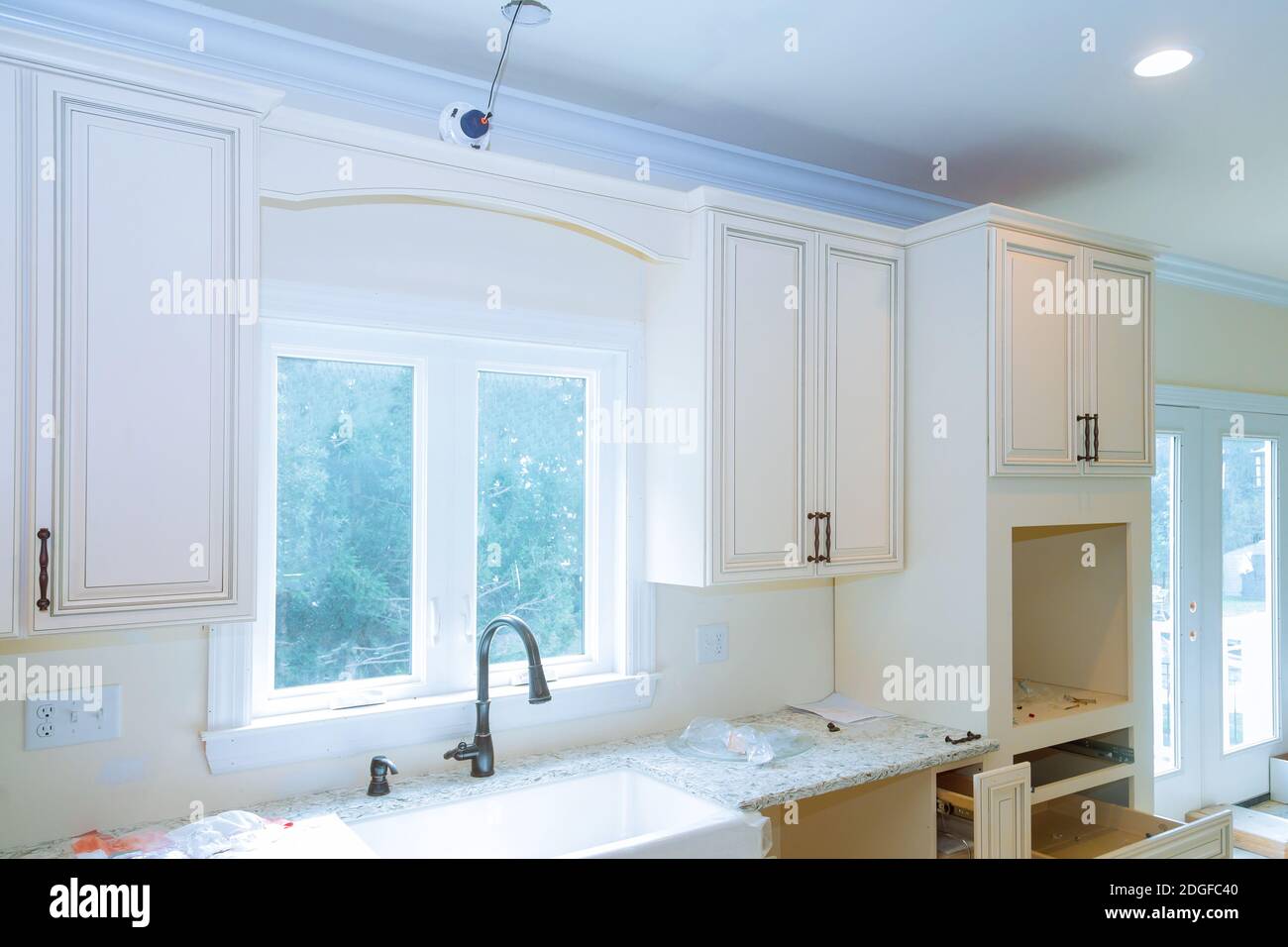 Moderne Haushaltsschränke mit neuen Geräten und Waschbecken in der Küche Stockfoto