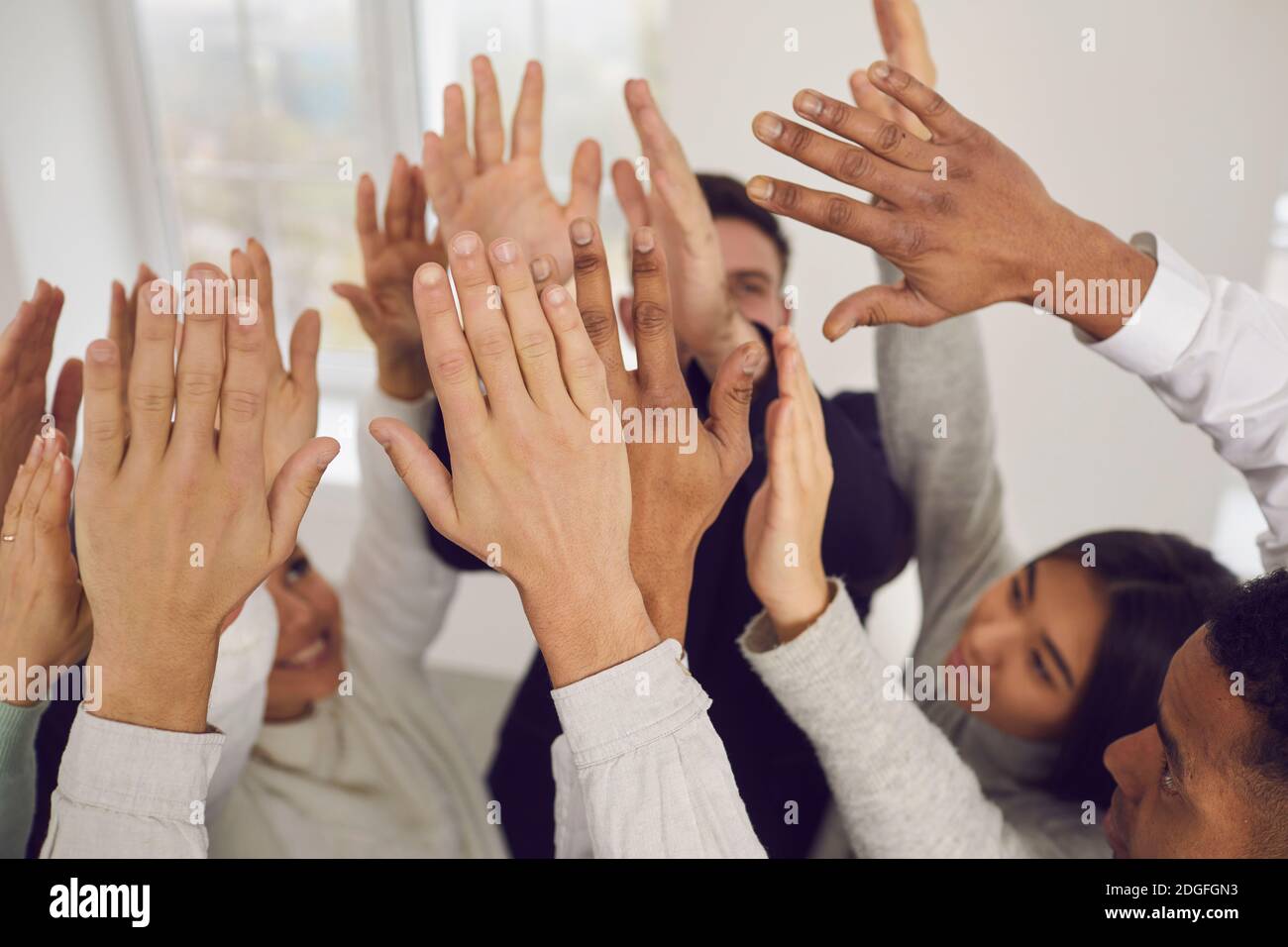 Team von glücklichen jungen Mixed-Race-Business-Leute, die ihre Hände heben Hoch in der Luft Stockfoto