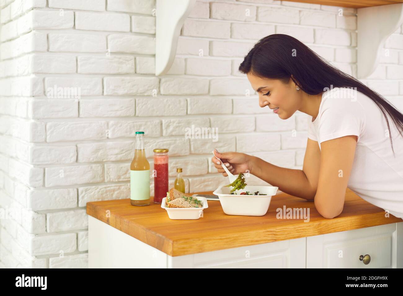 Junge lächelnde Frau genießen gesunde Box Abendessen Bestellung geliefert Zu Hause Stockfoto