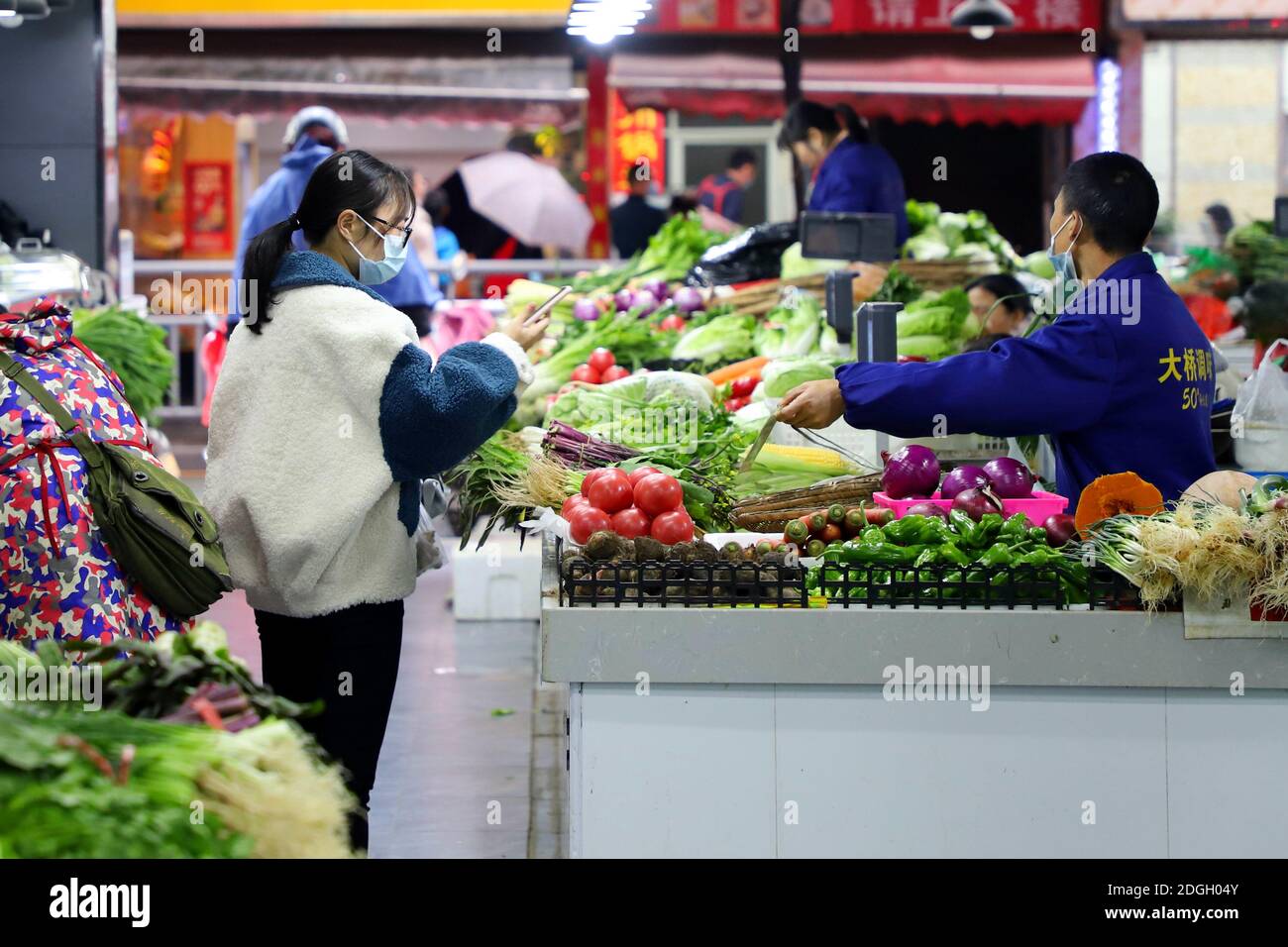 Auf einem Gemüsemarkt in Yichang, südchinesische Provinz Hubei, kaufen Menschen Gemüse ein, 21. November 2020. Stockfoto