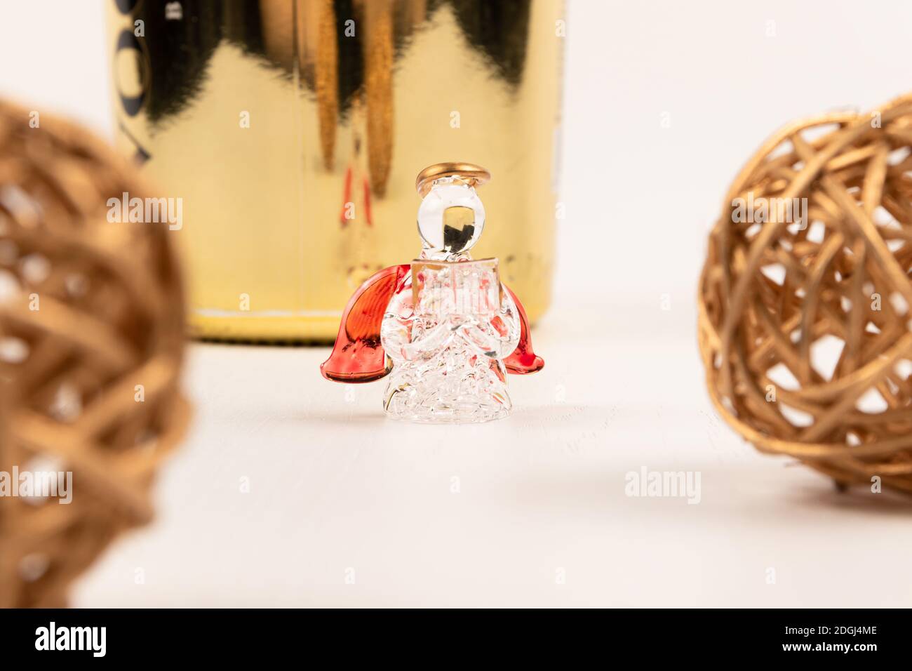 Souvenir Kristallengel, goldene Kugeln und Champagner-Geschenkflasche auf weißem Holztisch Stockfoto