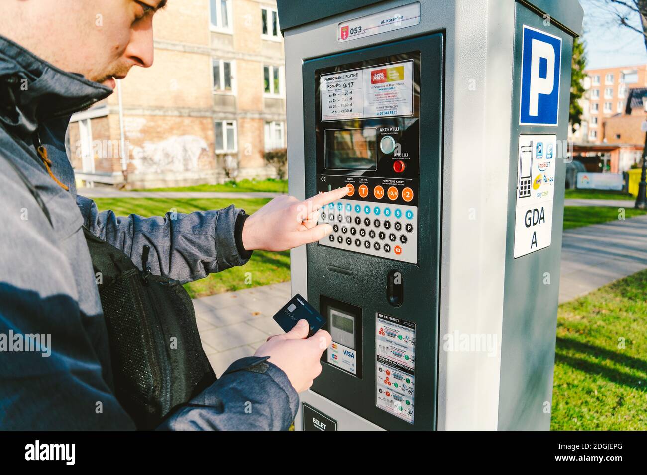 Man zahlt für das Parken mit einer Kreditkarte mit NFS-Technologie. Einfache Zahlung. Zahlungsprozess im Automatenparkplatz. Zahler Stockfoto