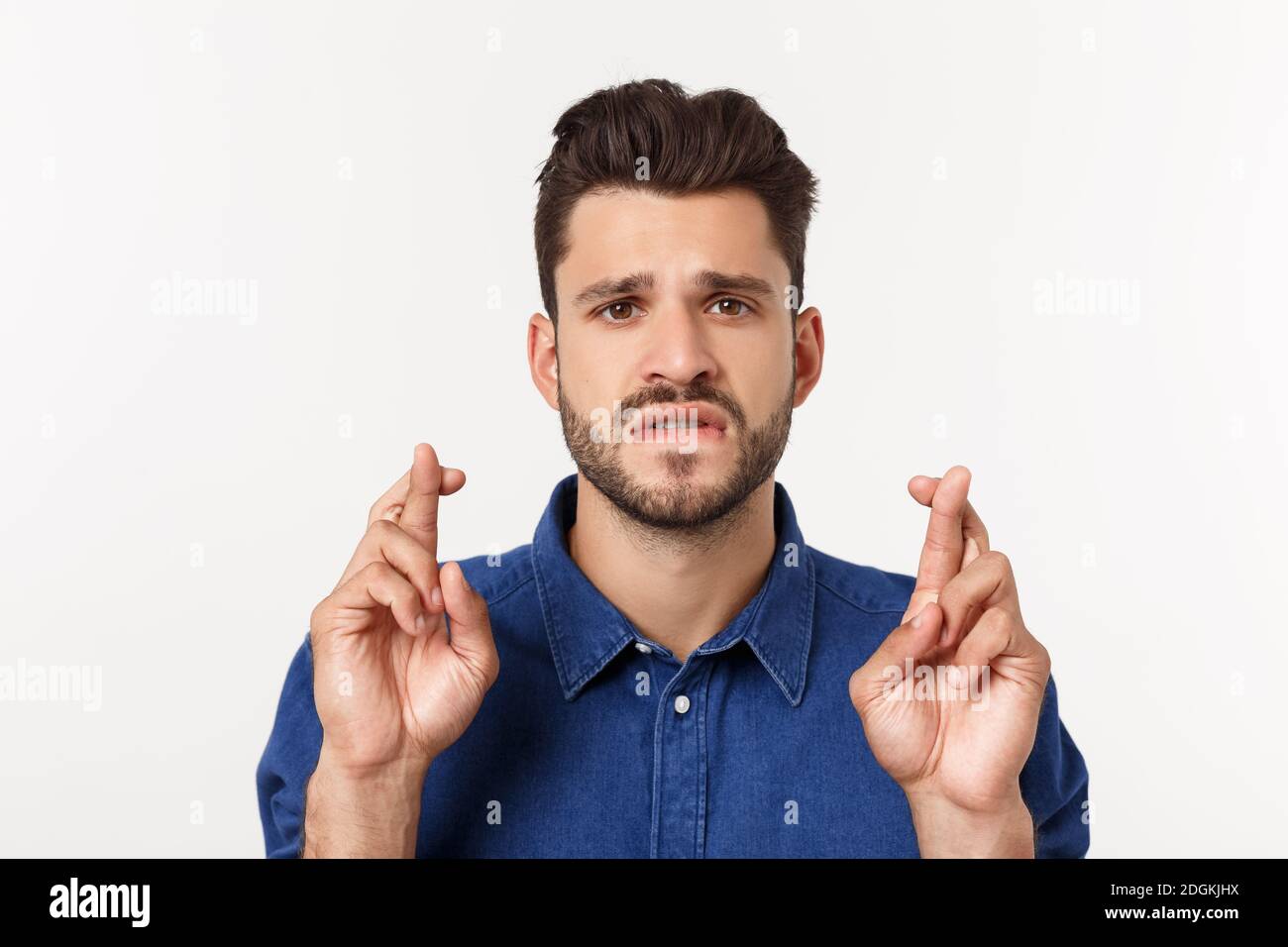 Nahaufnahme des enttäuschten gestressten bärtigen jungen Mannes im Hemd über weißem Hintergrund. Stockfoto