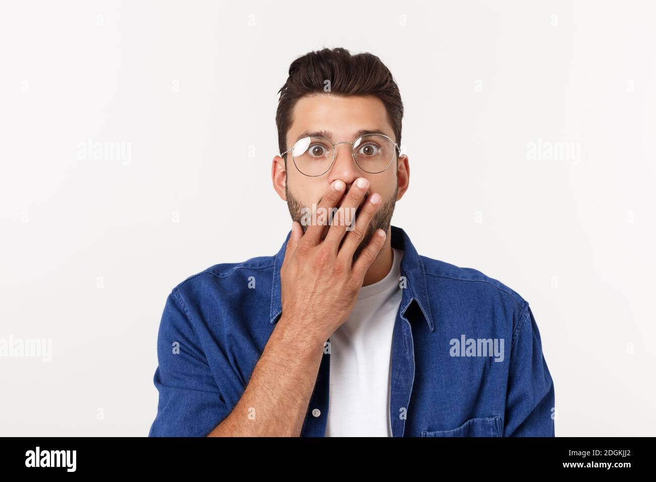 Nahaufnahme des enttäuschten gestressten bärtigen jungen Mannes im Hemd über weißem Hintergrund. Stockfoto