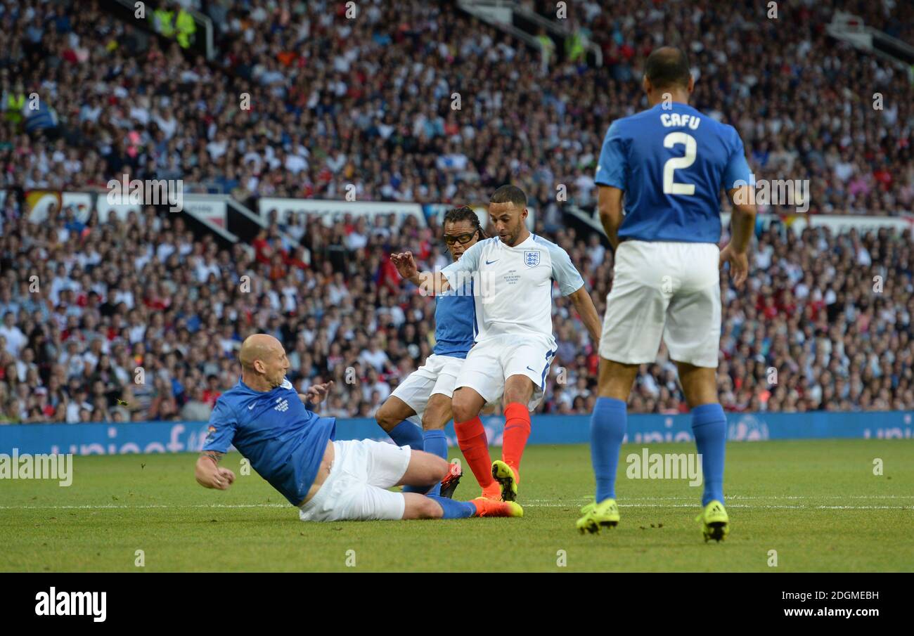 Marvin Humes und Jaap Stam kämpfen während der Soccer Aid 2016 in Old Trafford, Manchester, um den Ball. Stockfoto