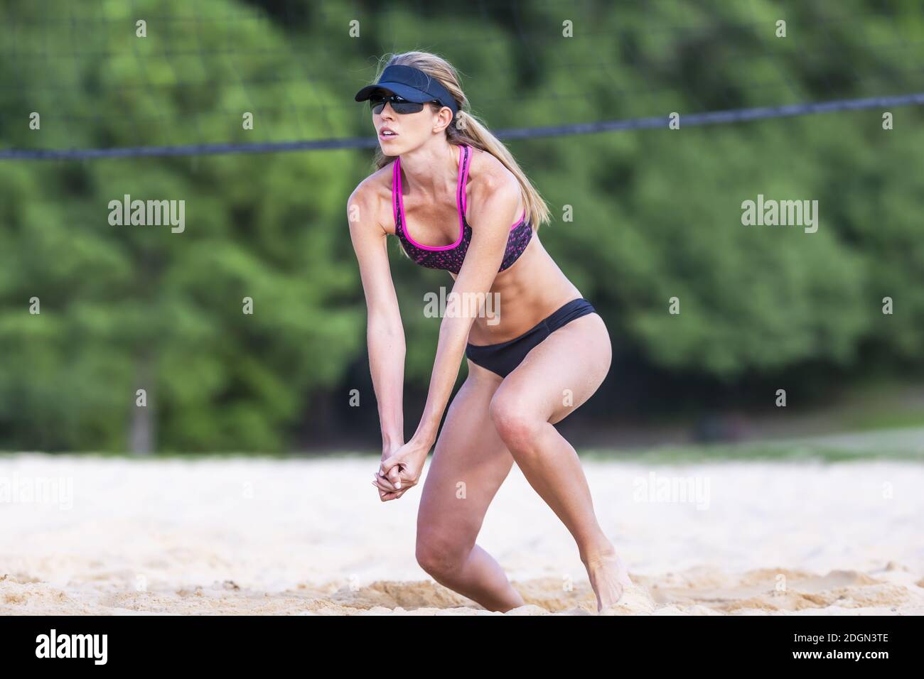 Weibliche Volleyballspielerin an EINEM Sandstrand während EINES Wettkampfes Übereinstimmung Stockfoto