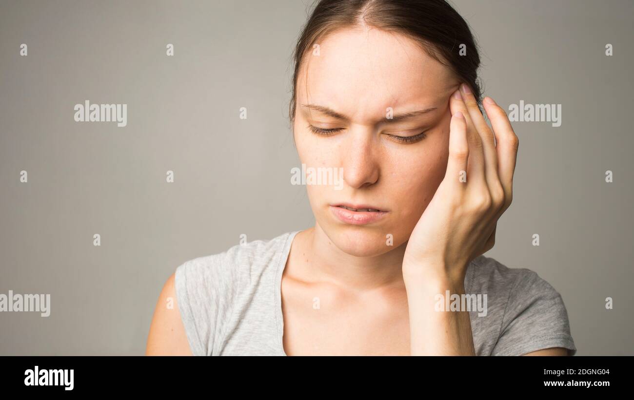 Junge schöne Frau mit Kopfschmerzen Stockfoto