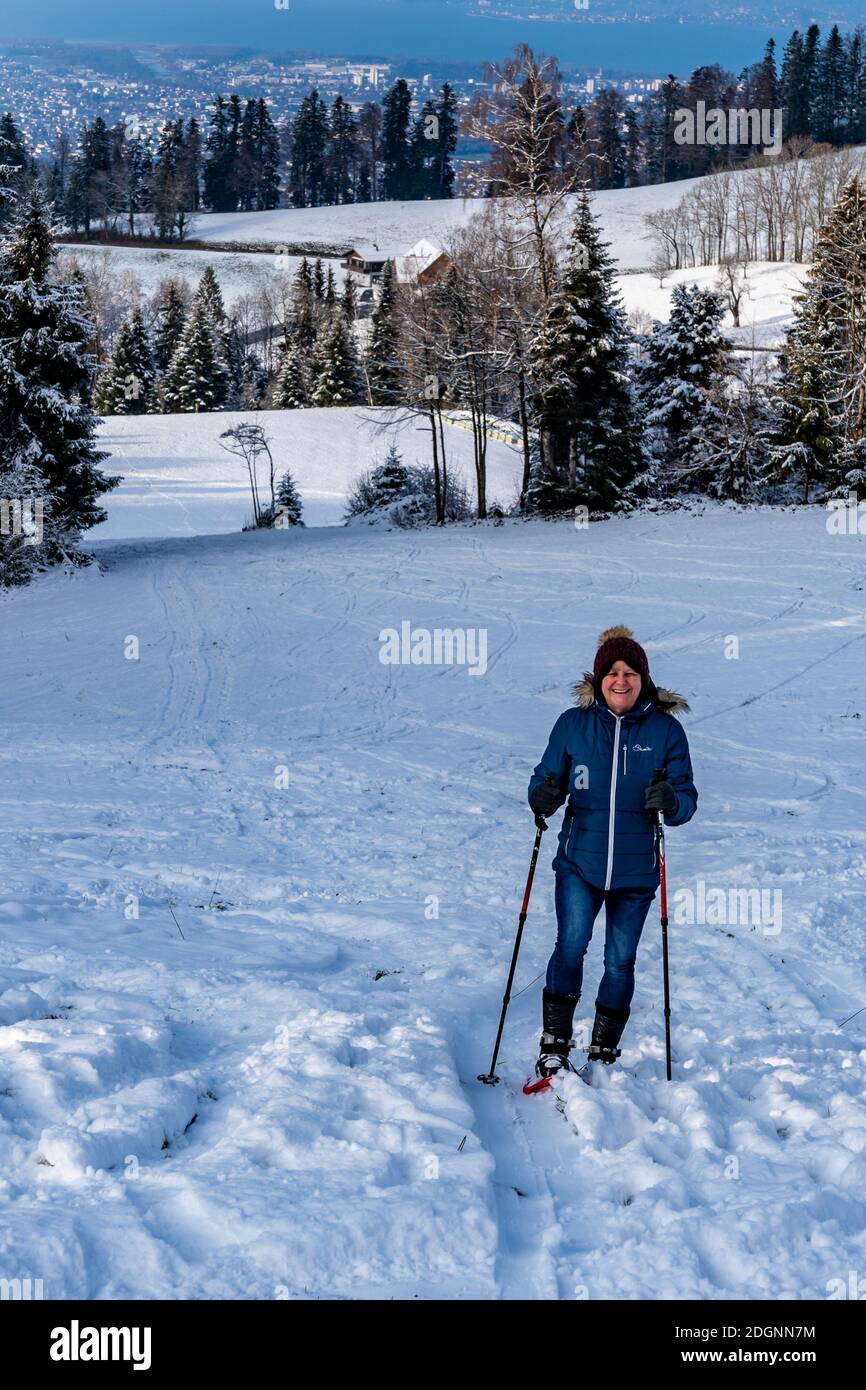 Wandern Sie die Linie mit Schneeschuhen im Winterwunderland. Frischer, schneebedeckter Wald mit Schneeschuhwanderern, Abend über den Bodensee. Schneeschuh Stockfoto