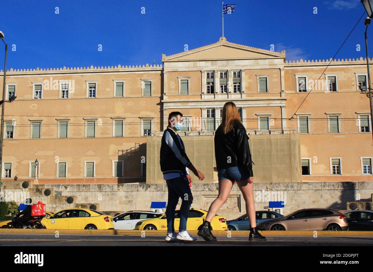 Menschen, die im Zentrum von Athen mit dem griechischen Parlament im Hintergrund spazieren - Athen, Griechenland, 5. November 2020. Stockfoto
