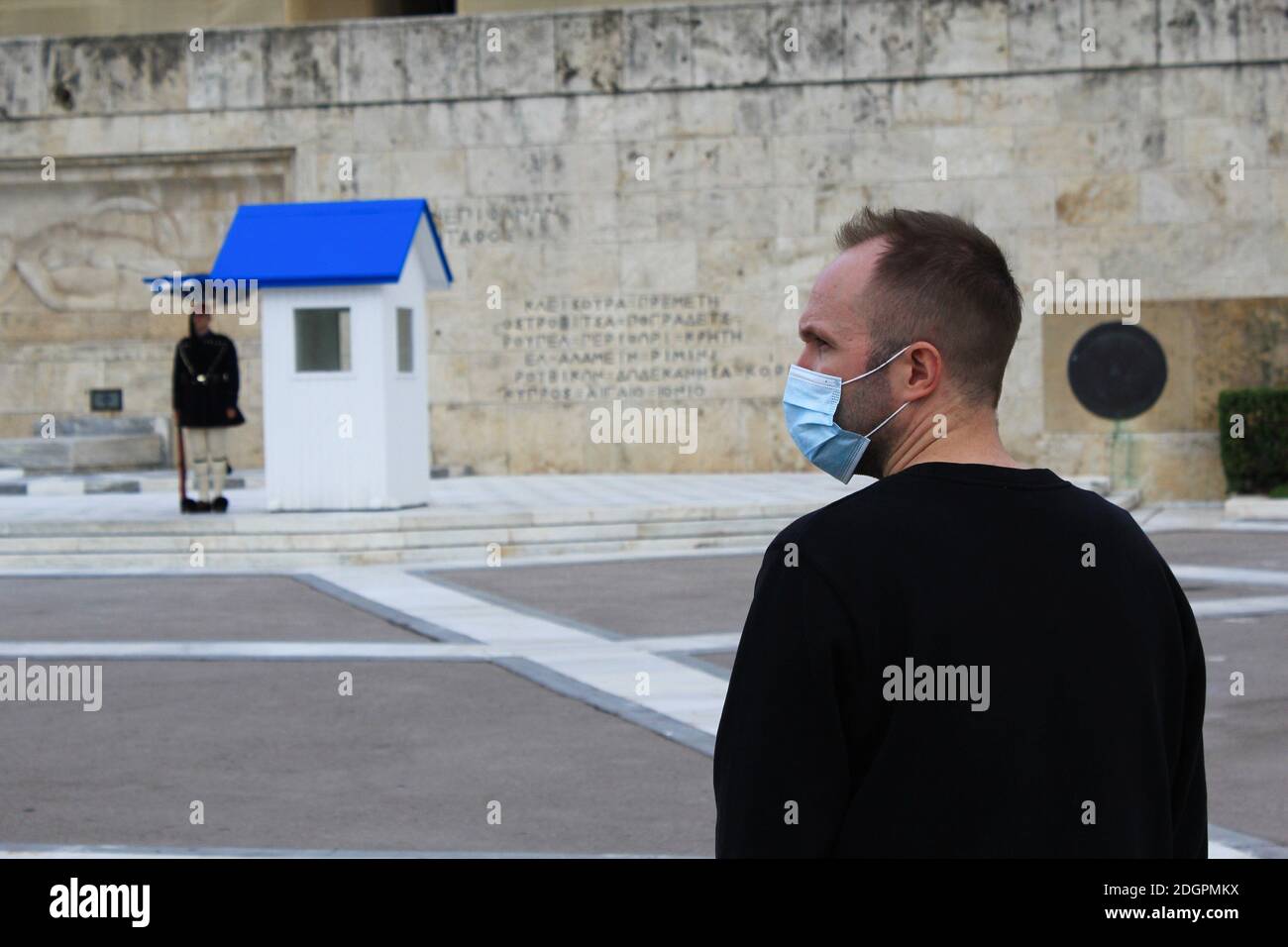 Mann mit Maske steht vor dem Grab des unbekannten Soldaten im griechischen Parlament in Athen, Griechenland, 6. November 2020. Stockfoto