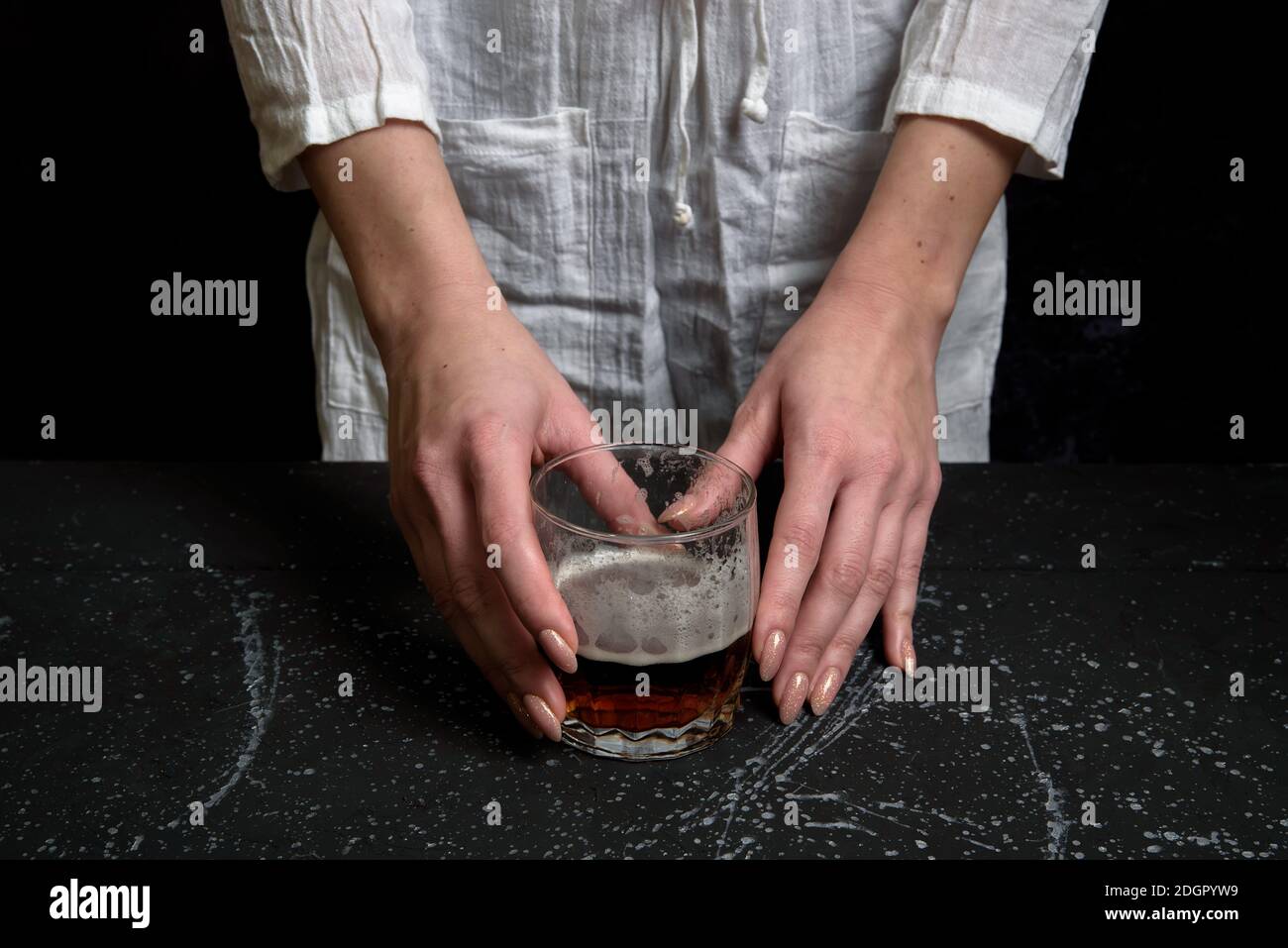 Frau Hand holdin ein Glas mit dunklem Bier Stockfoto