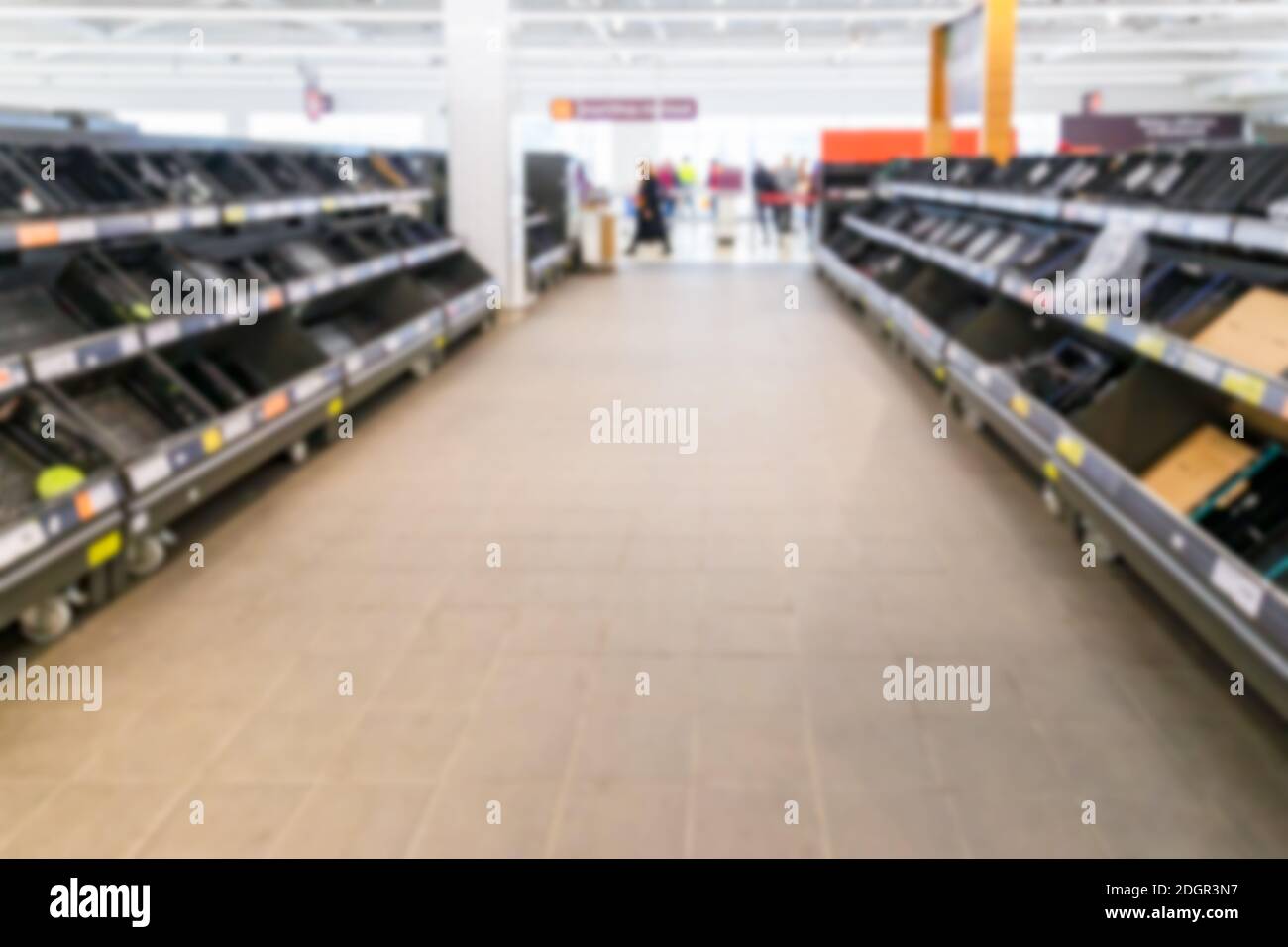 Verschwommenes Innenhintergrundbild leerer Supermarktregale aufgrund von Covid-19, Coronavirus, induzierter Lagerhaltung Stockfoto