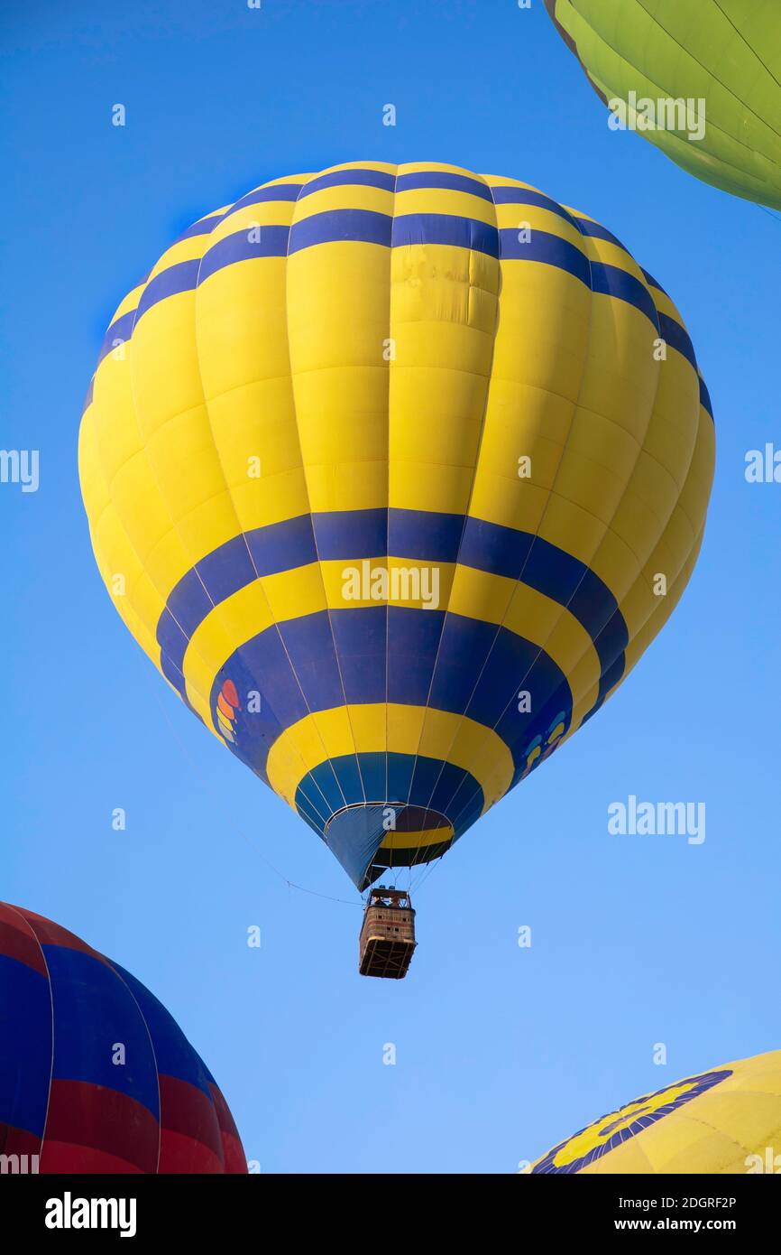 Gelber und blauer Heißluftballon am blauen Himmel Stockfoto