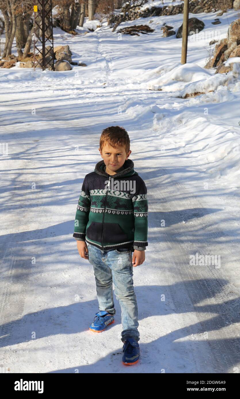 NIGDE,TÜRKEI-JANUAR 15:Unidentifizierter kleiner Junge, der mitten auf einer verschneiten Straße steht.Januar 15,2017 in Nigde,Türkei. Stockfoto