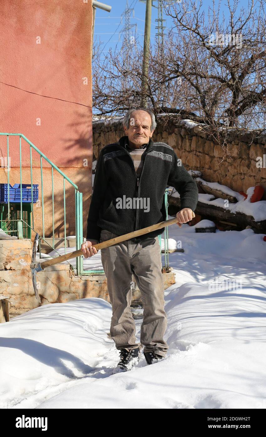 NIGDE,TÜRKEI-JANUAR 15:Unidentifizierter Mann steht vor seinem Haus mit einer Spitzhacke.Januar 15,2017 in Nigde,Türkei. Stockfoto