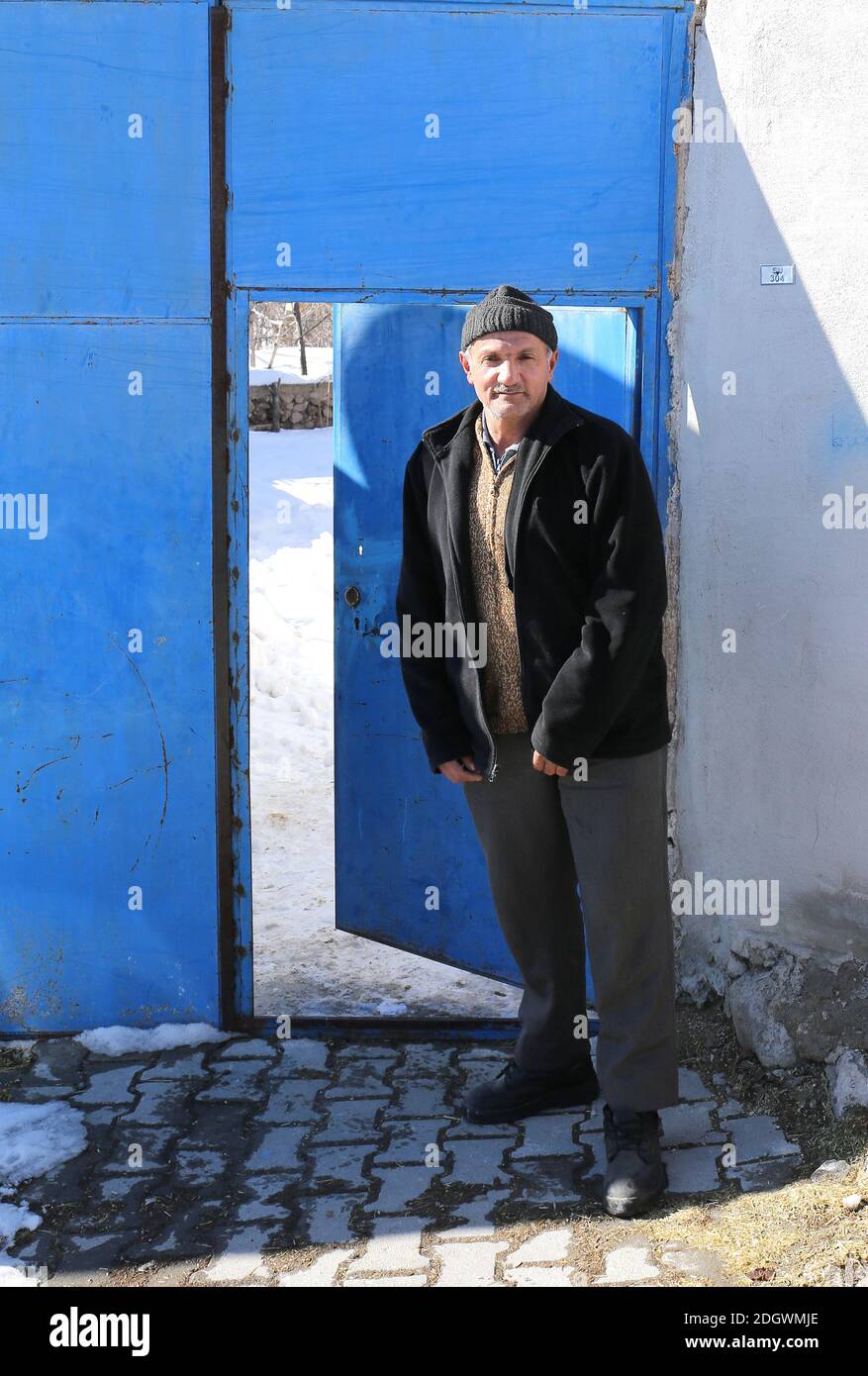 NIGDE,TÜRKEI-JANUAR 15:Unidentifizierter Mann steht vor Metal Blue Door.Januar 15,2017 in Nigde,Türkei. Stockfoto